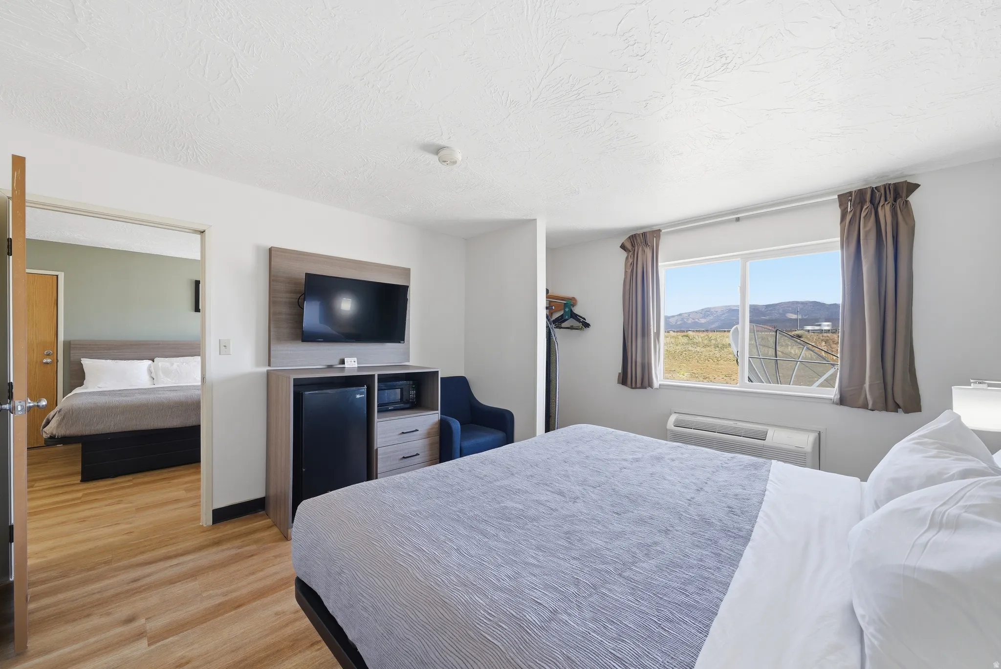 Bedroom featuring light wood-style floors and a ptac unit