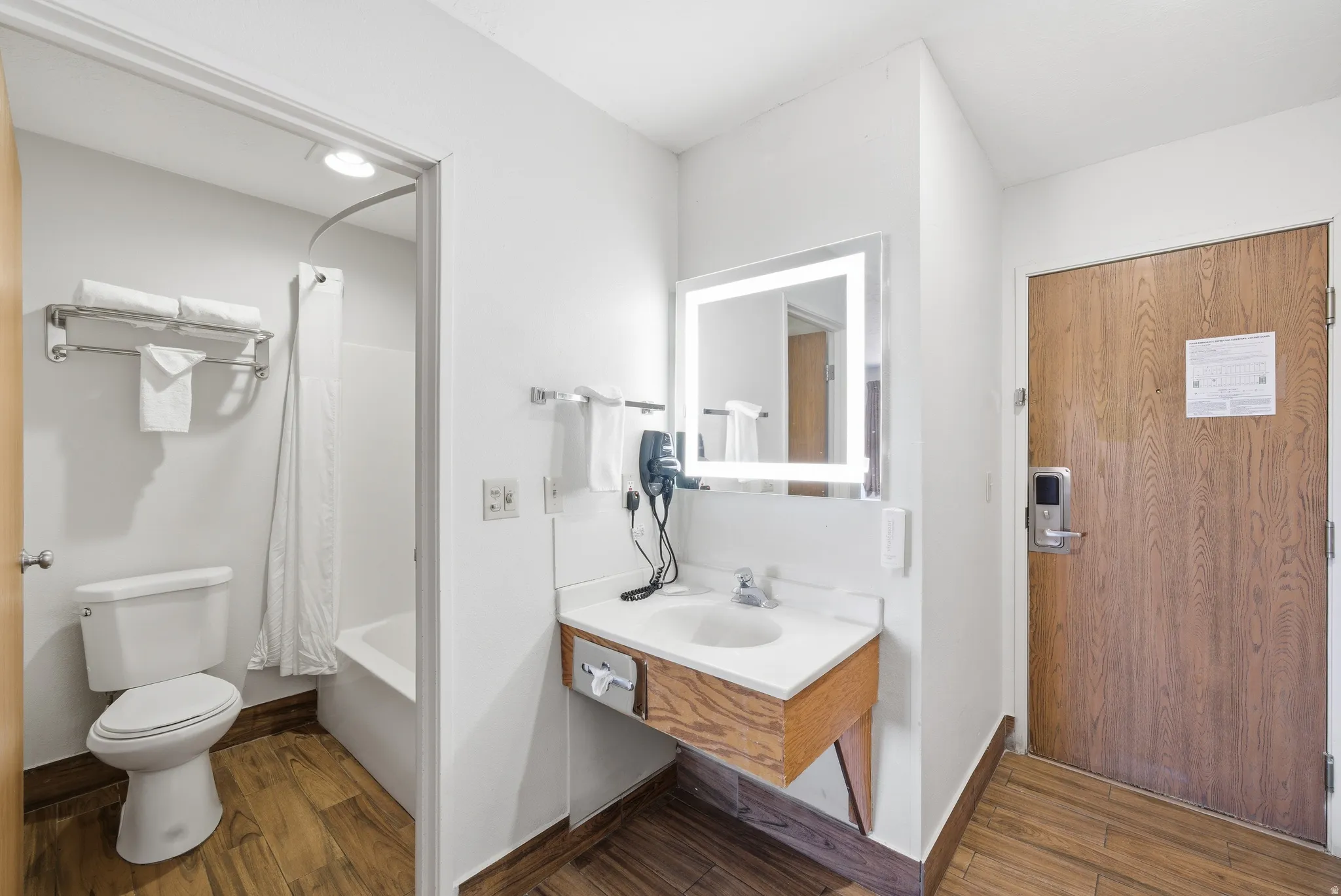 Bathroom featuring vanity, dark wood-style floors, and shower / bathtub combination with curtain
