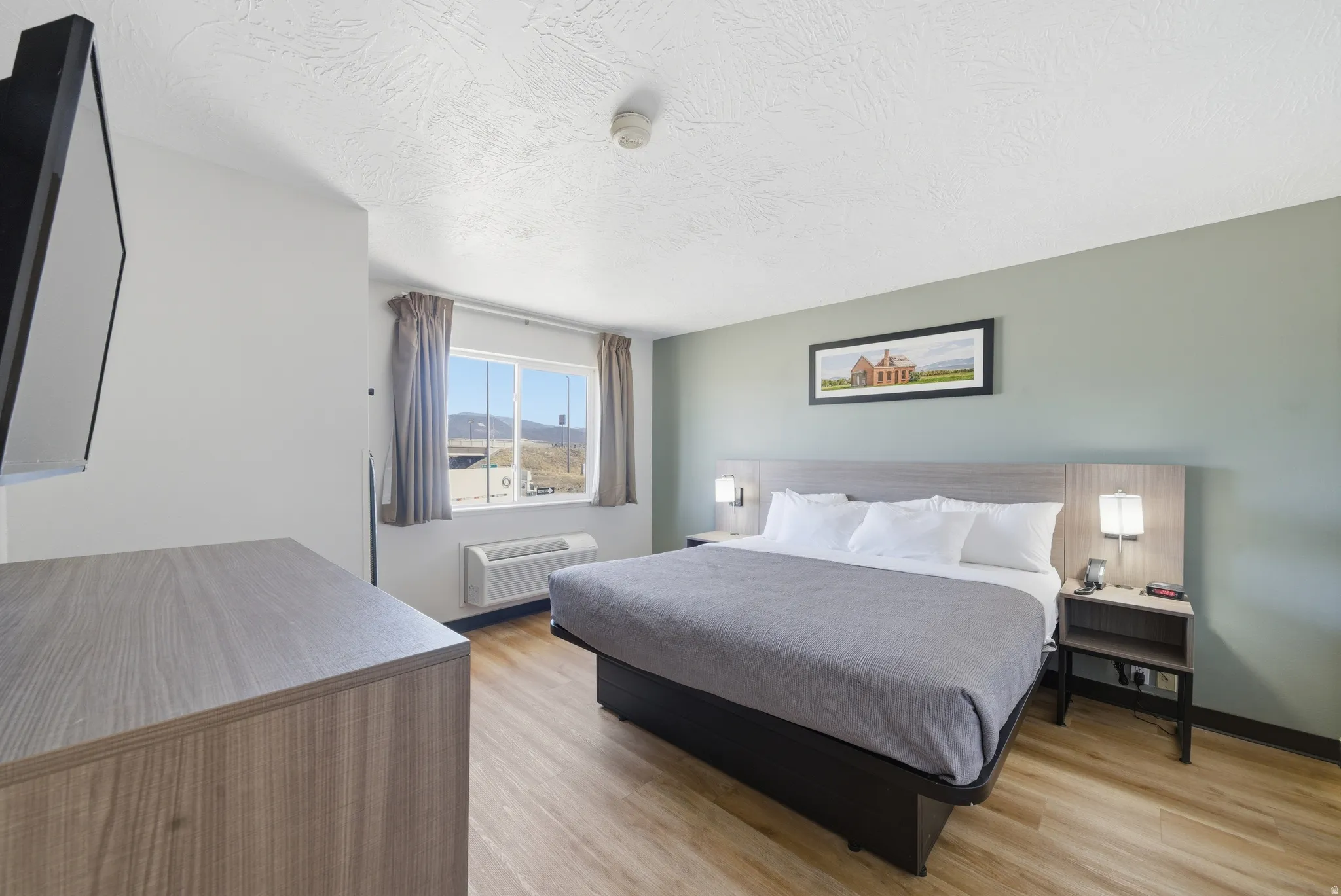Bedroom with light wood finished floors and a textured ceiling
