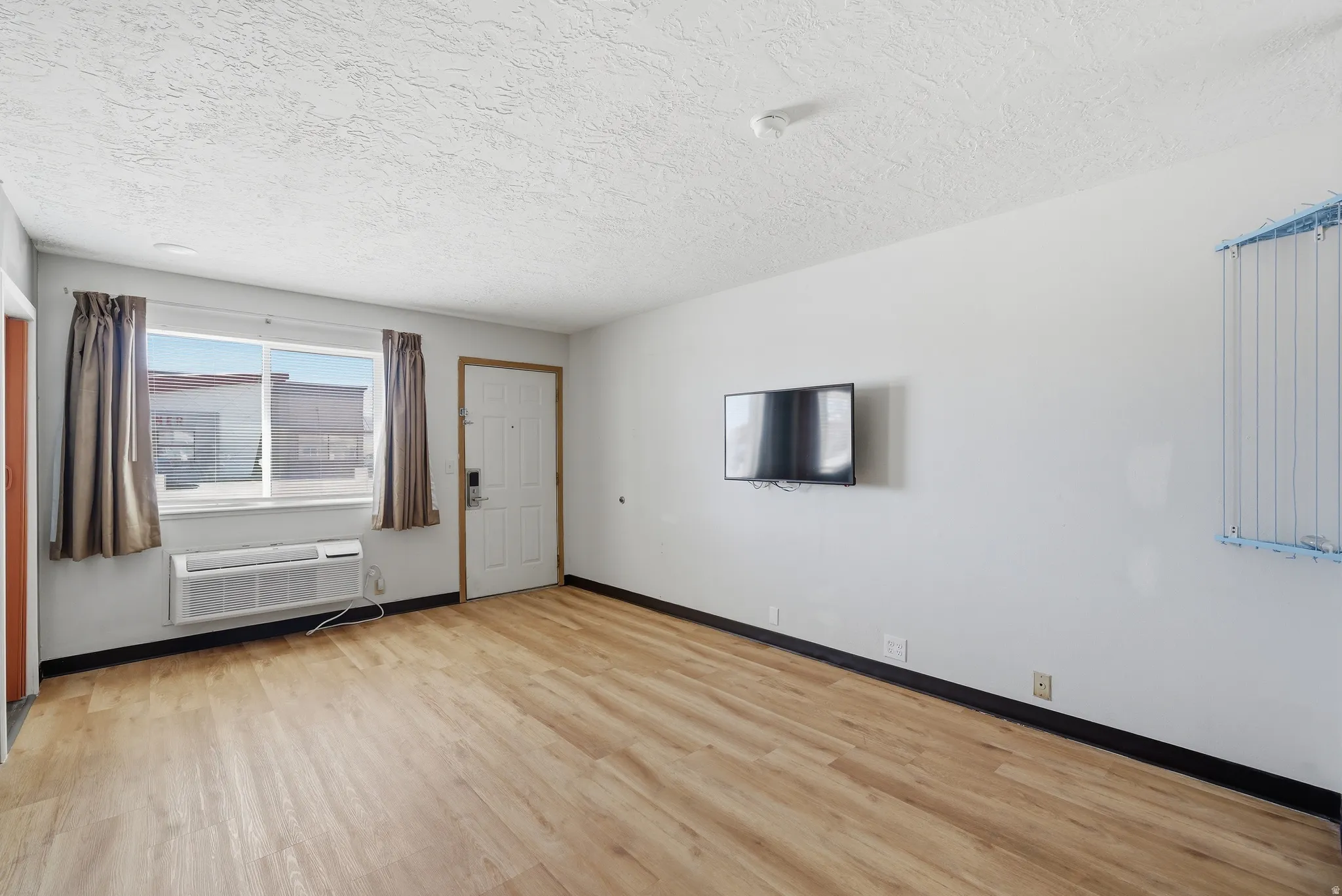 Unfurnished room with light wood finished floors and baseboards