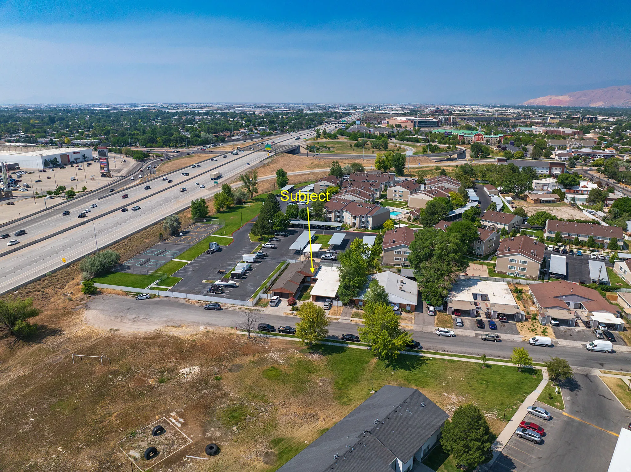 Aerial perspective showcasing the residential complex with multiple buildings and a parking lot