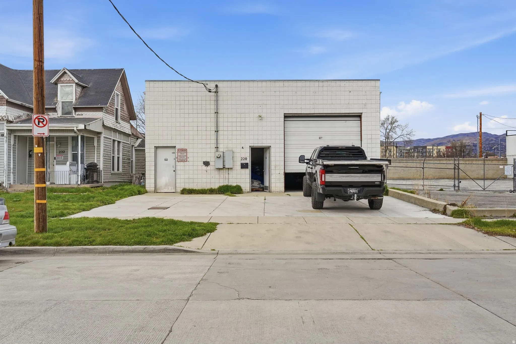 View of front of property with driveway, a mountain view, and an outdoor structure