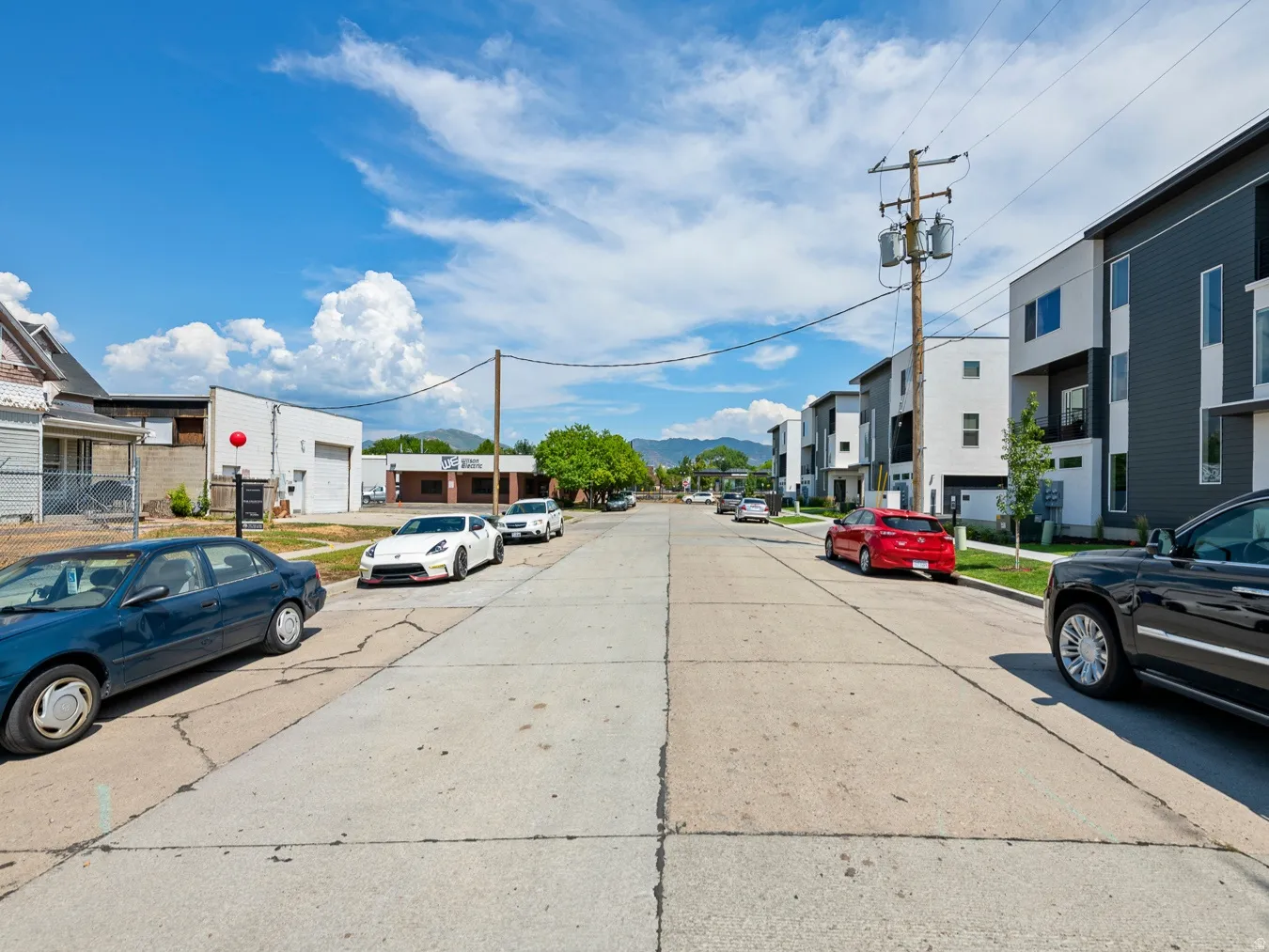 View of concrete street with a residential view, traffic signs, and curbs