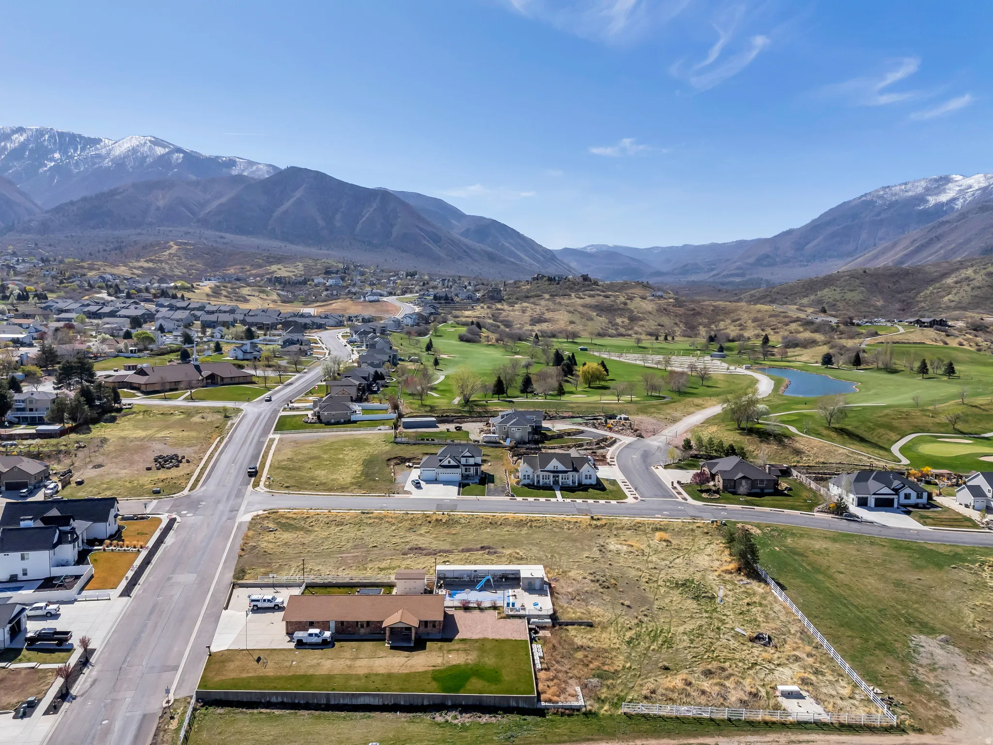 Aerial view of residential area with a golf club and a water and mountain view