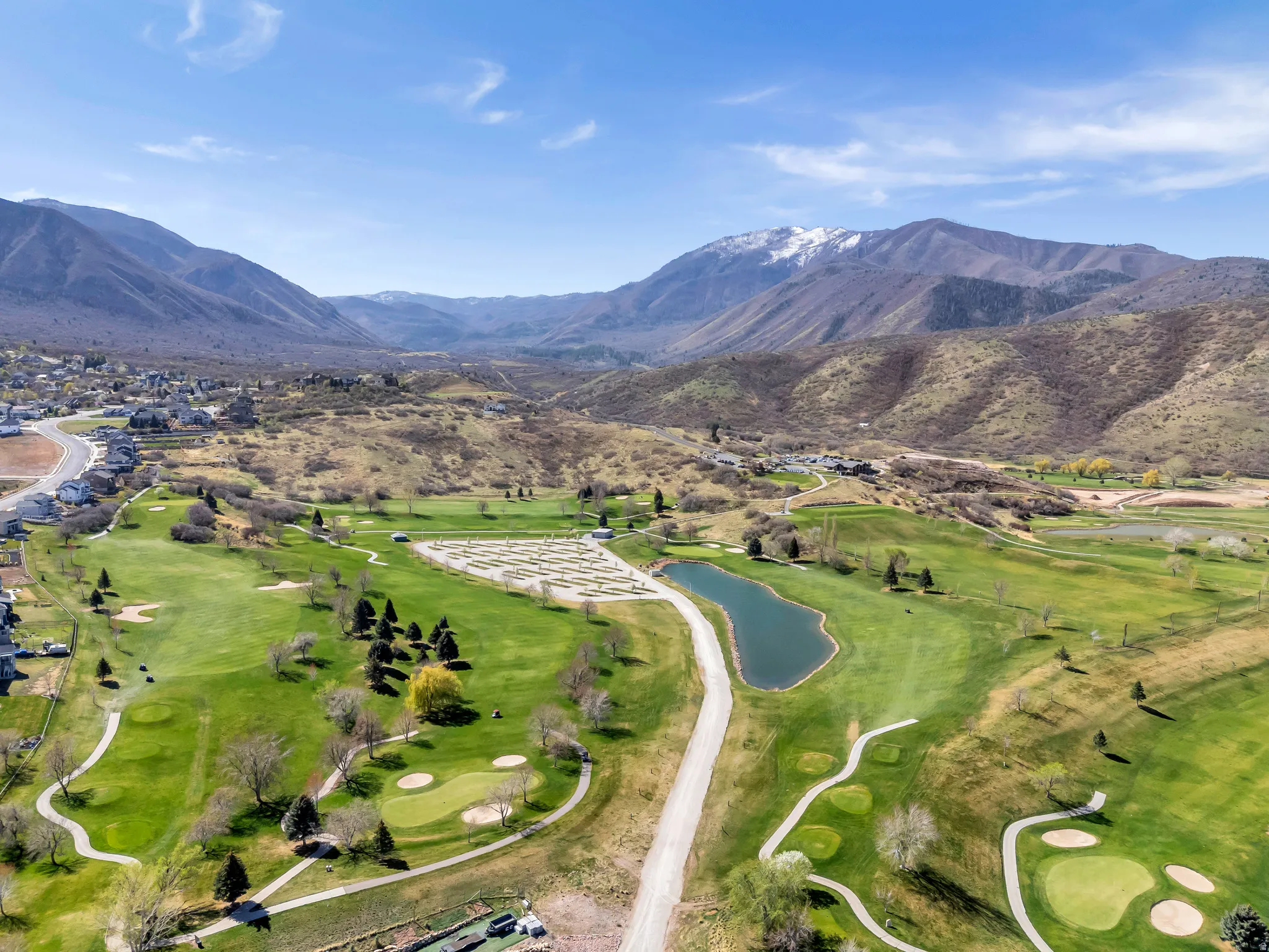 Drone / aerial view of a water and mountain view and a golf club
