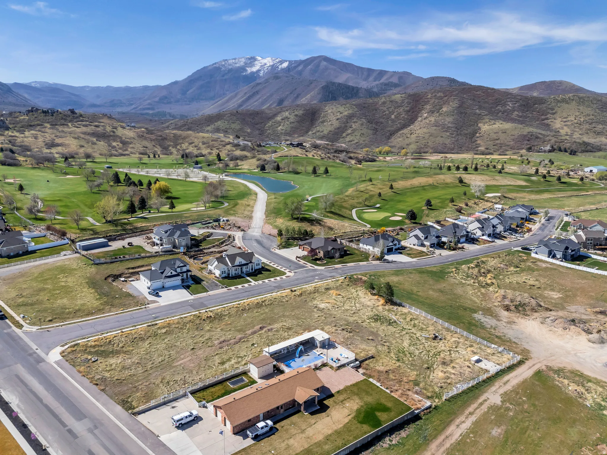 Aerial view of residential area with a local golf course and mountains