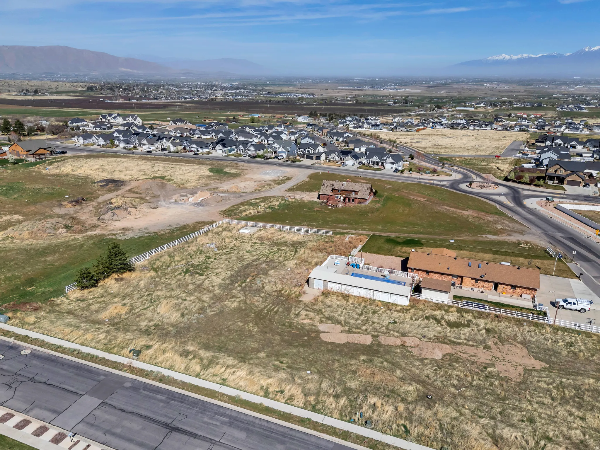 Aerial view of property's location with nearby suburban area and a mountainous background