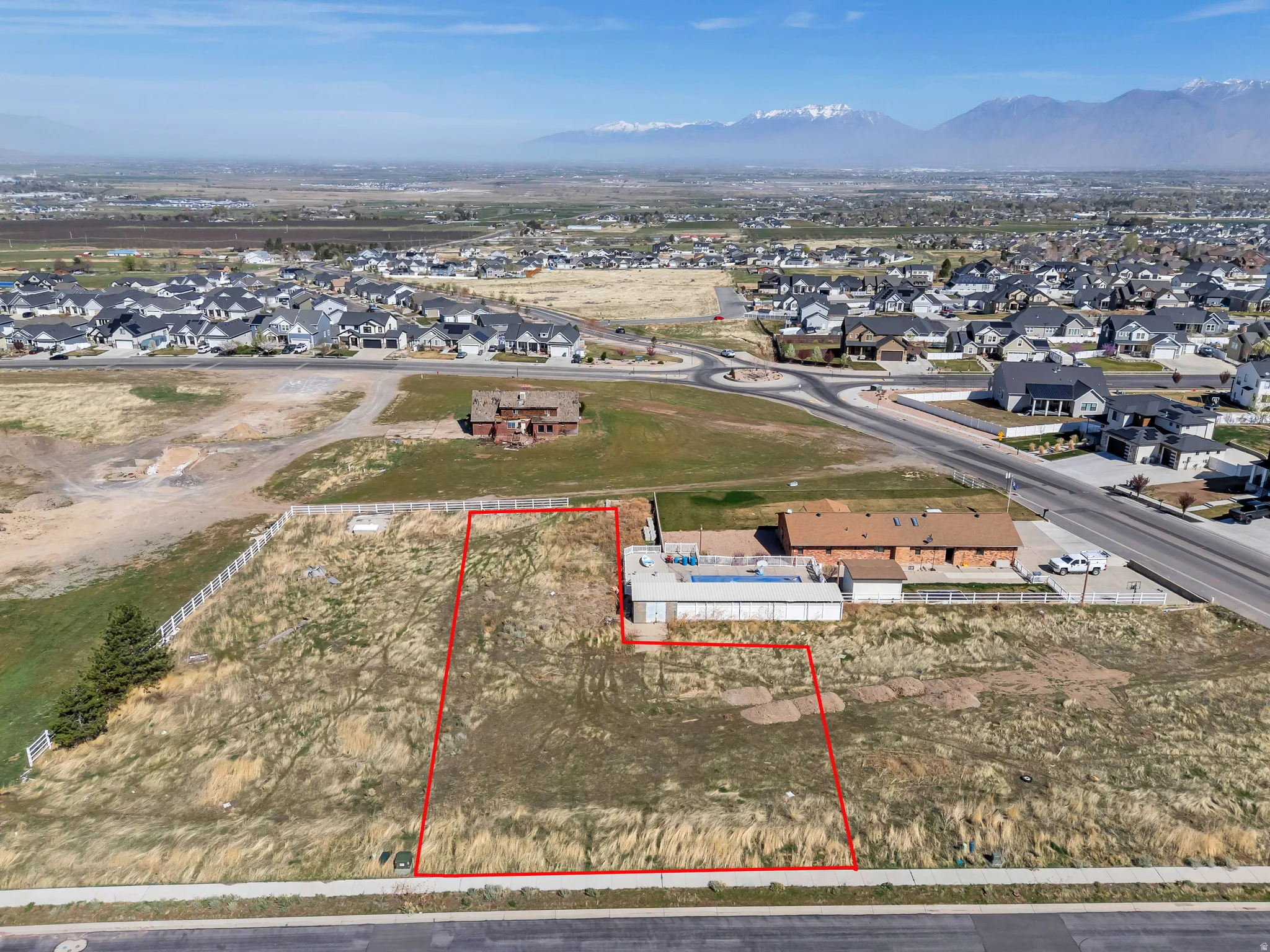 Aerial perspective of suburban area featuring property boundaries highlighted and a mountainous background