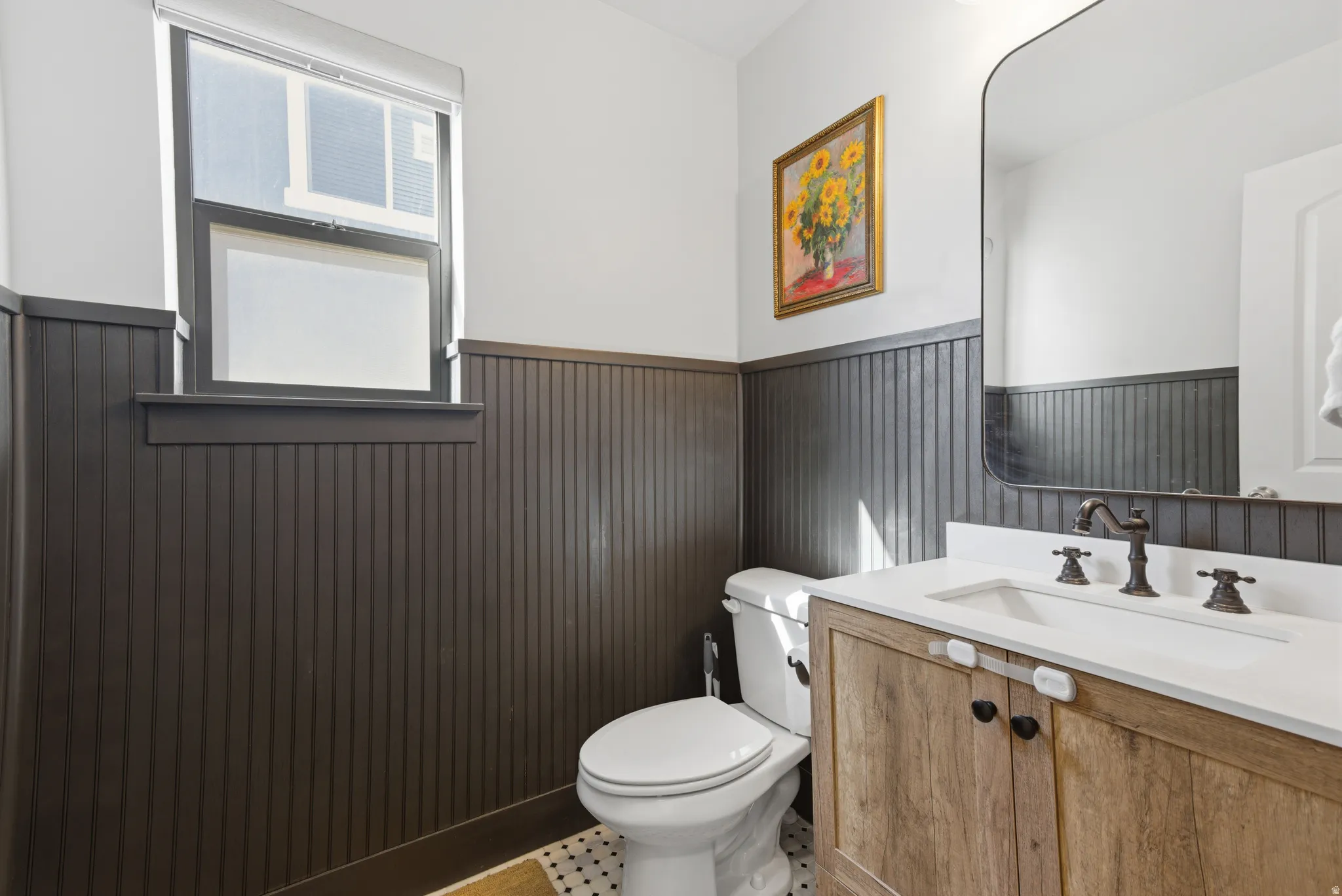 Half bath featuring vanity and a wainscoted wall