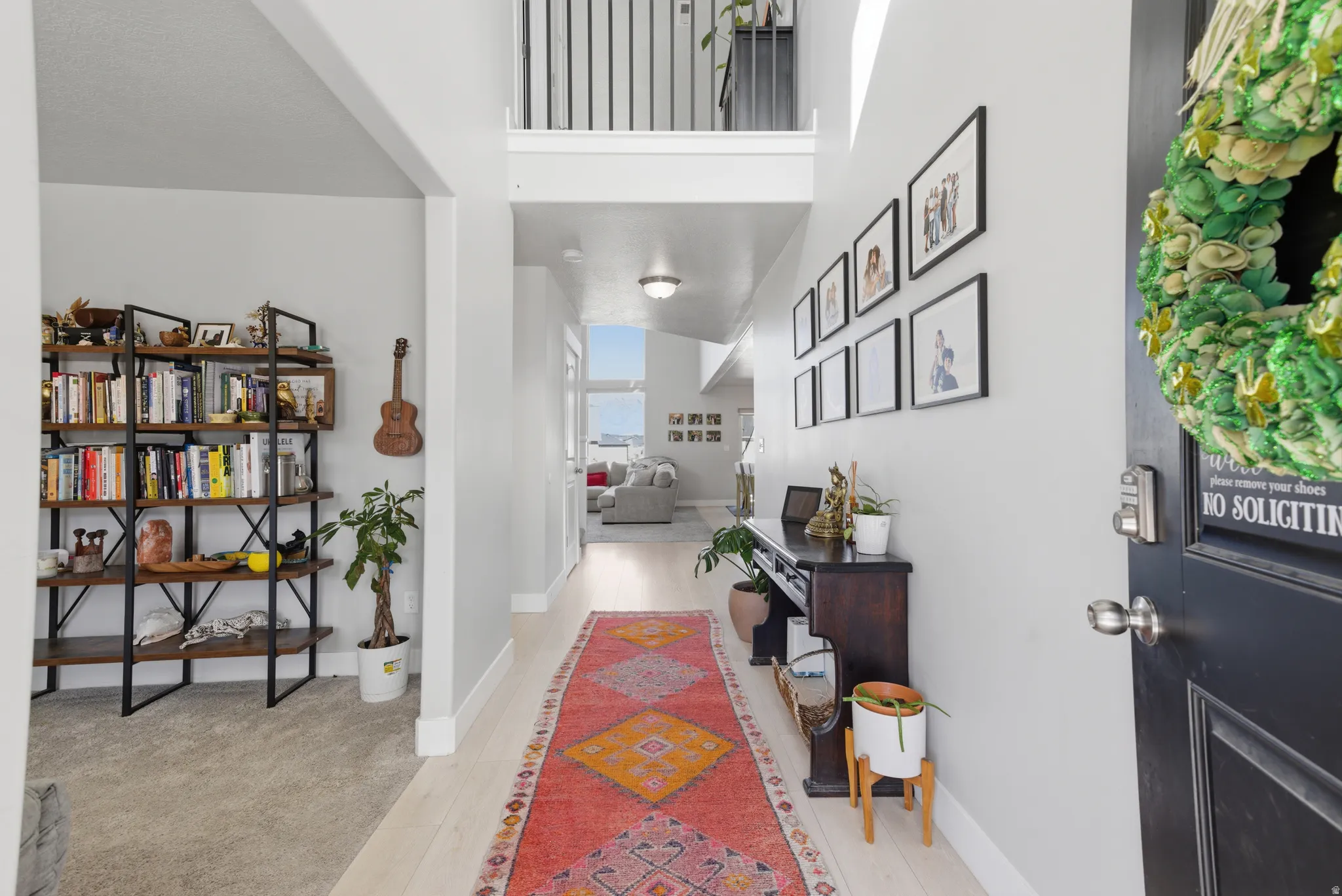 Corridor with a high ceiling and light wood-style flooring