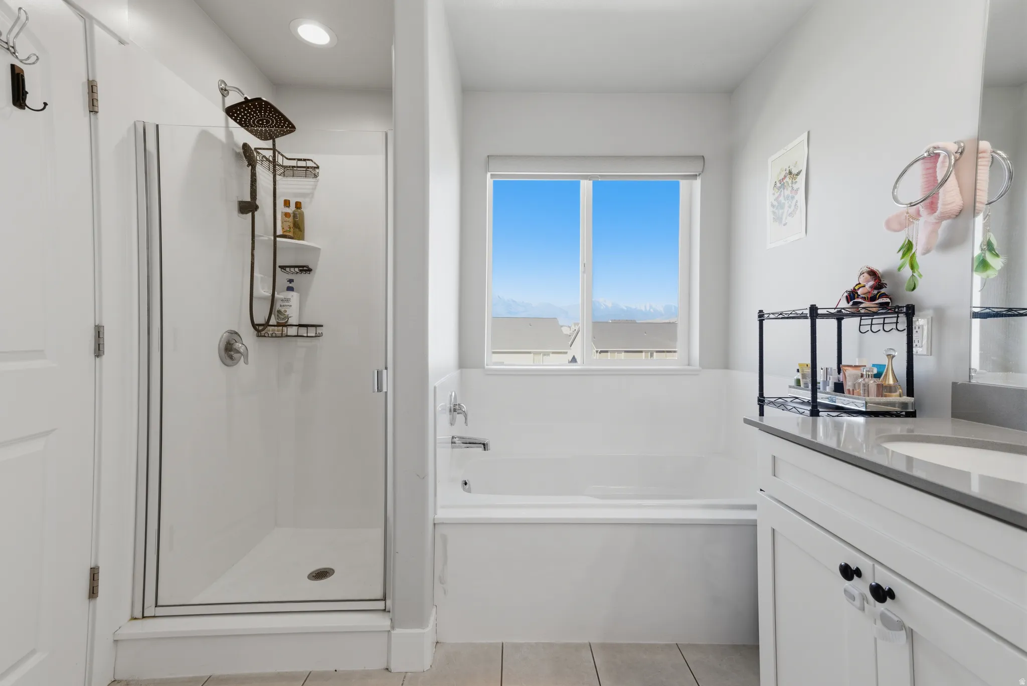 Bathroom with vanity, a stall shower, a bath, and light tile patterned floors