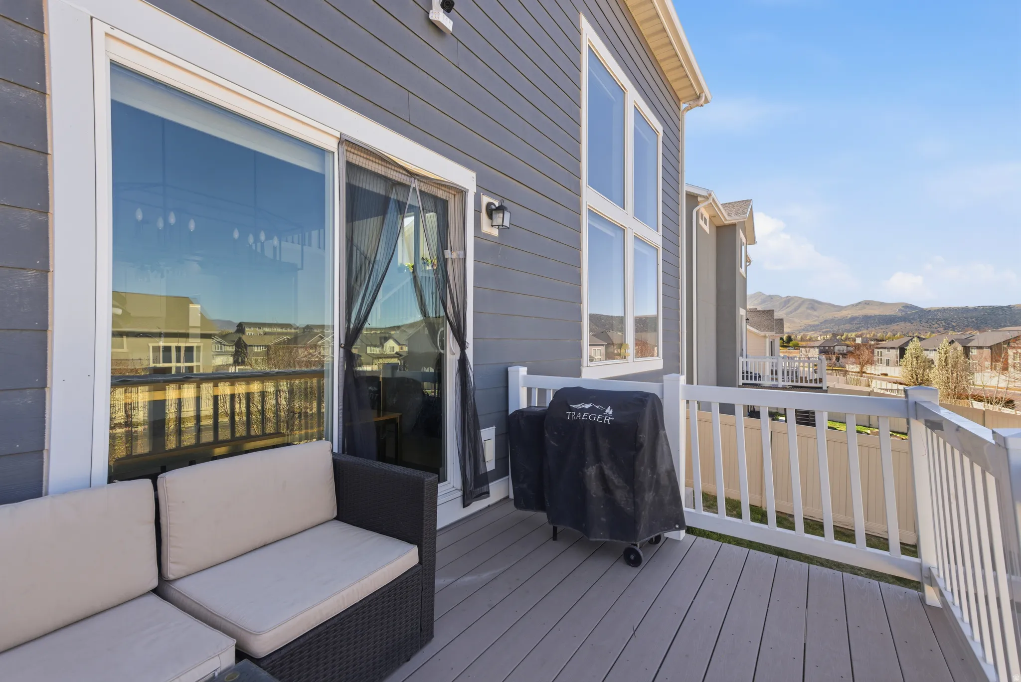 Wooden terrace featuring a residential view, grilling area, and a mountain view