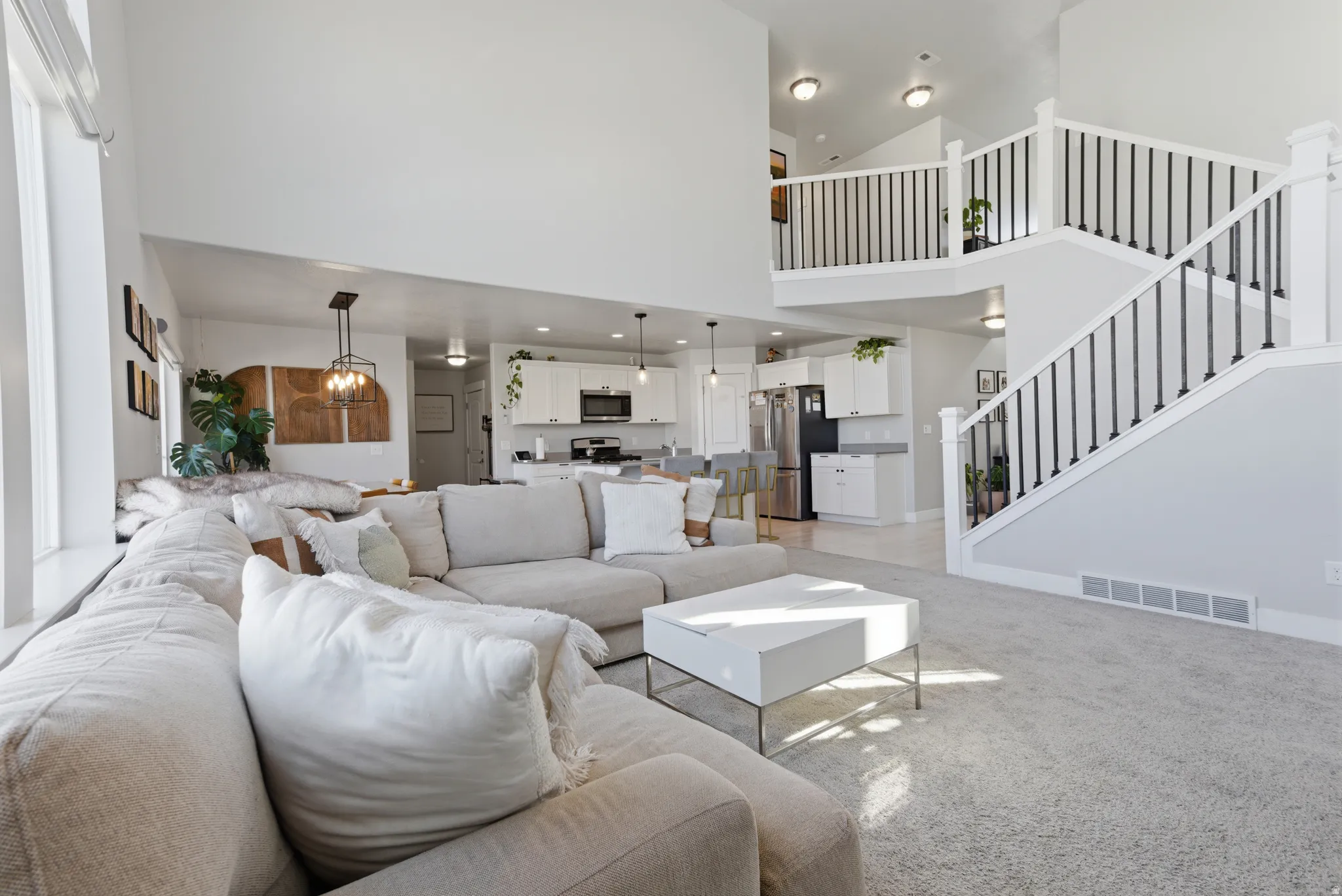 Living area with light carpet and a high ceiling