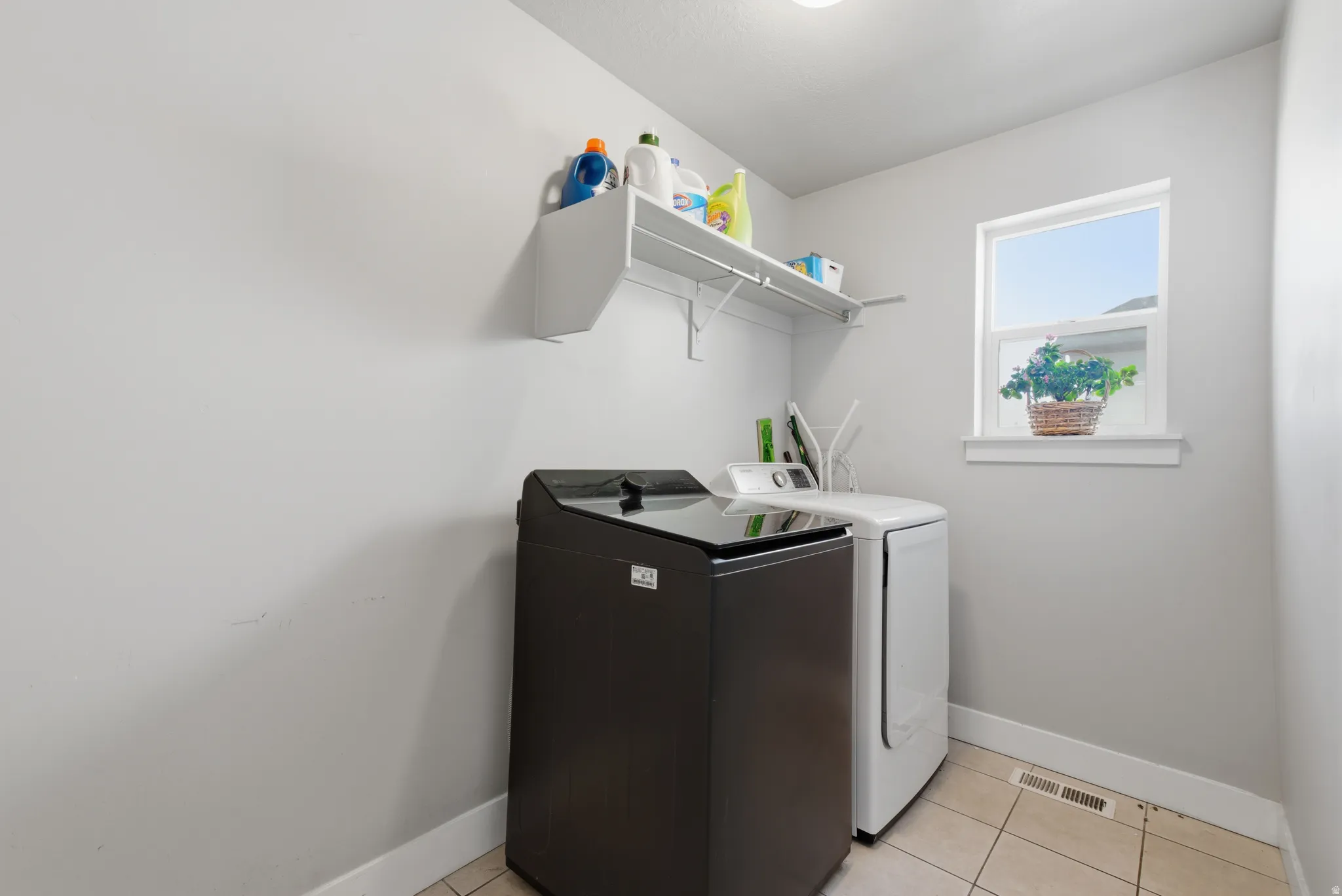 Laundry room with light tile patterned flooring and washing machine and dryer