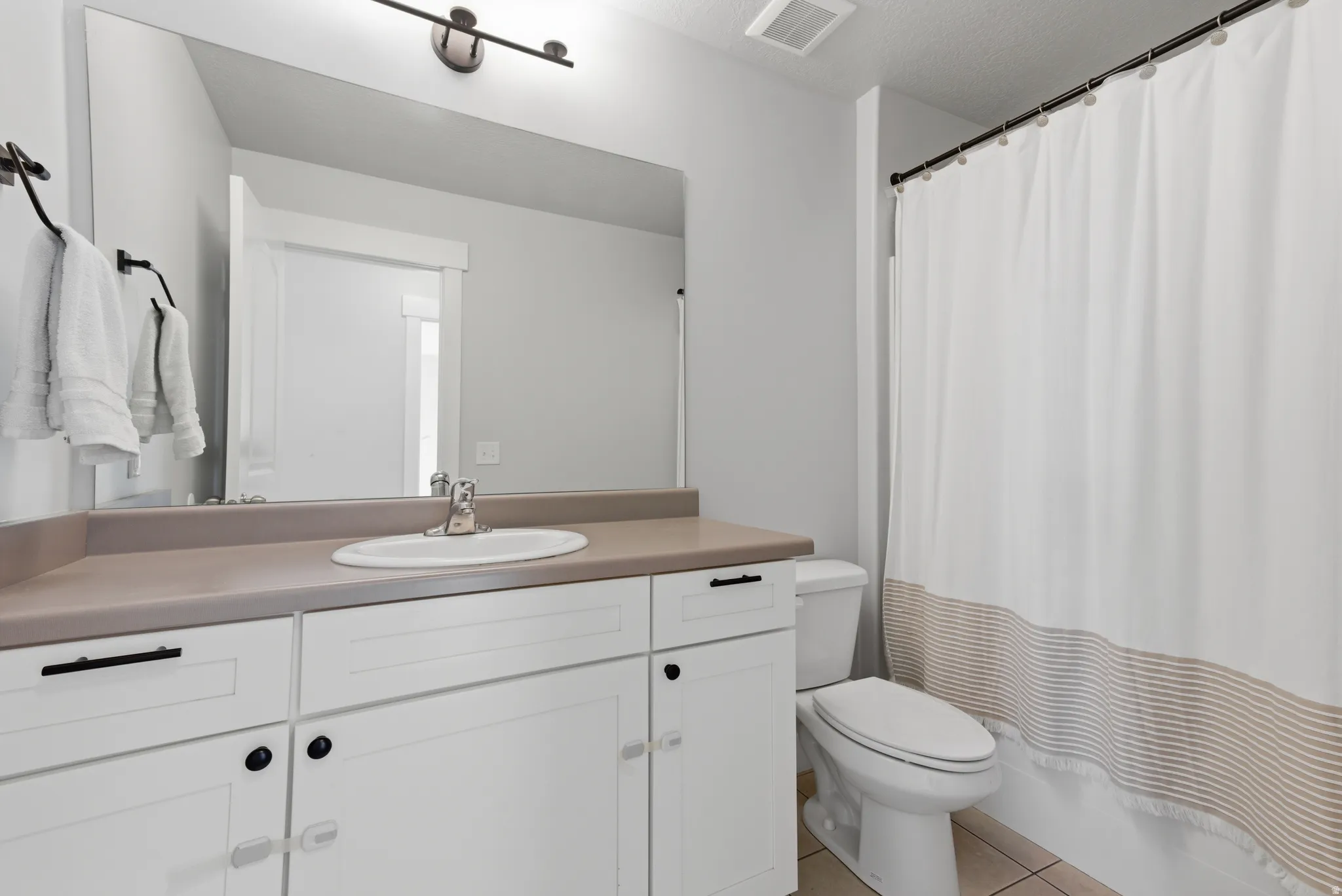 Full bathroom with vanity and light tile patterned floors