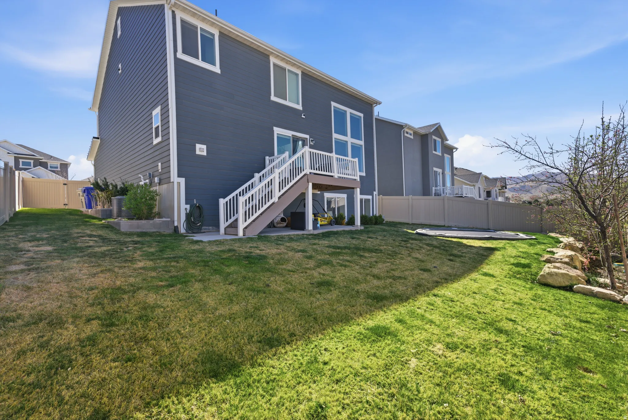Rear view of house featuring a patio area, a fenced backyard, and a deck