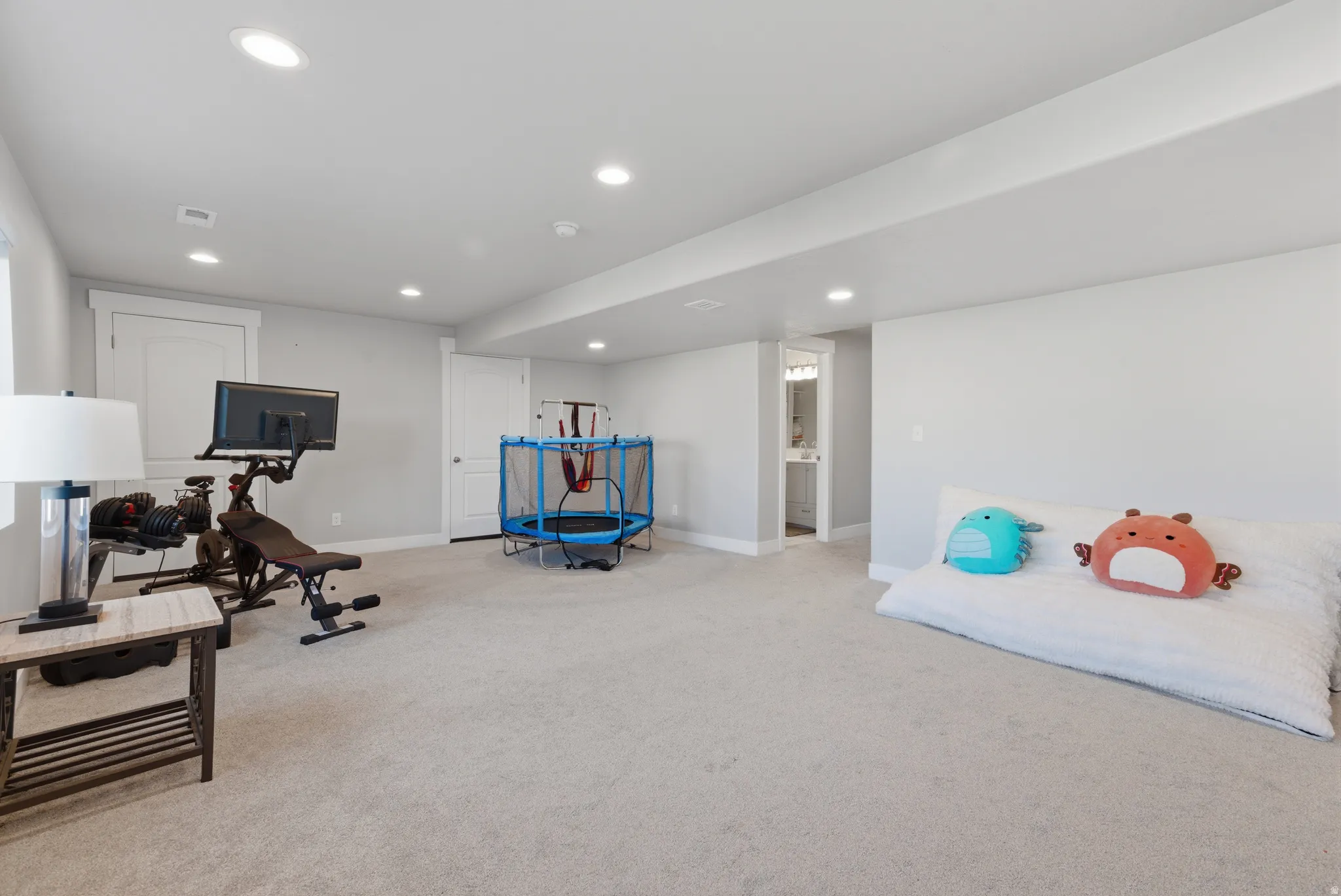 Workout room with light carpet and recessed lighting