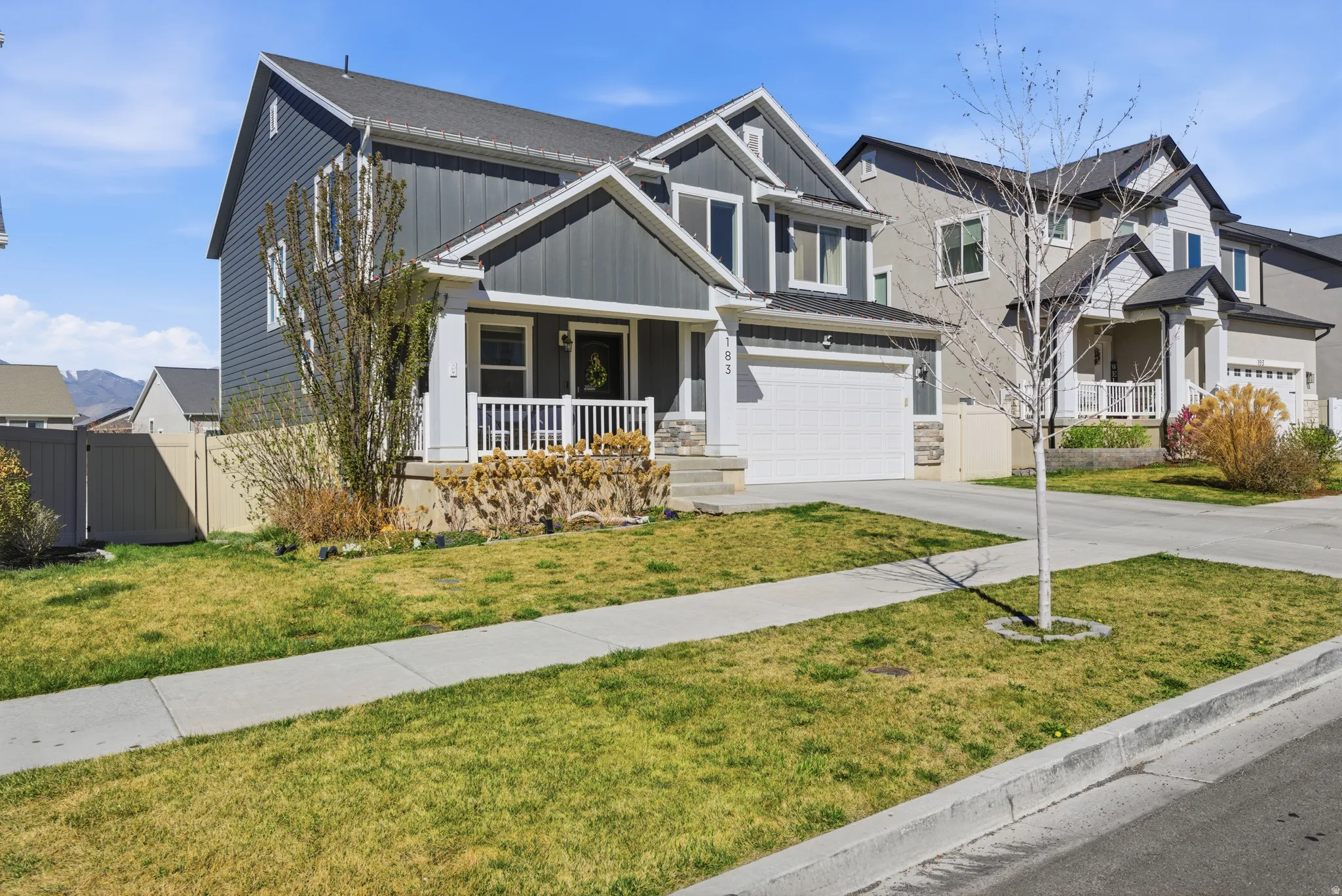 Craftsman house with board and batten siding, covered porch, concrete driveway, and an attached garage