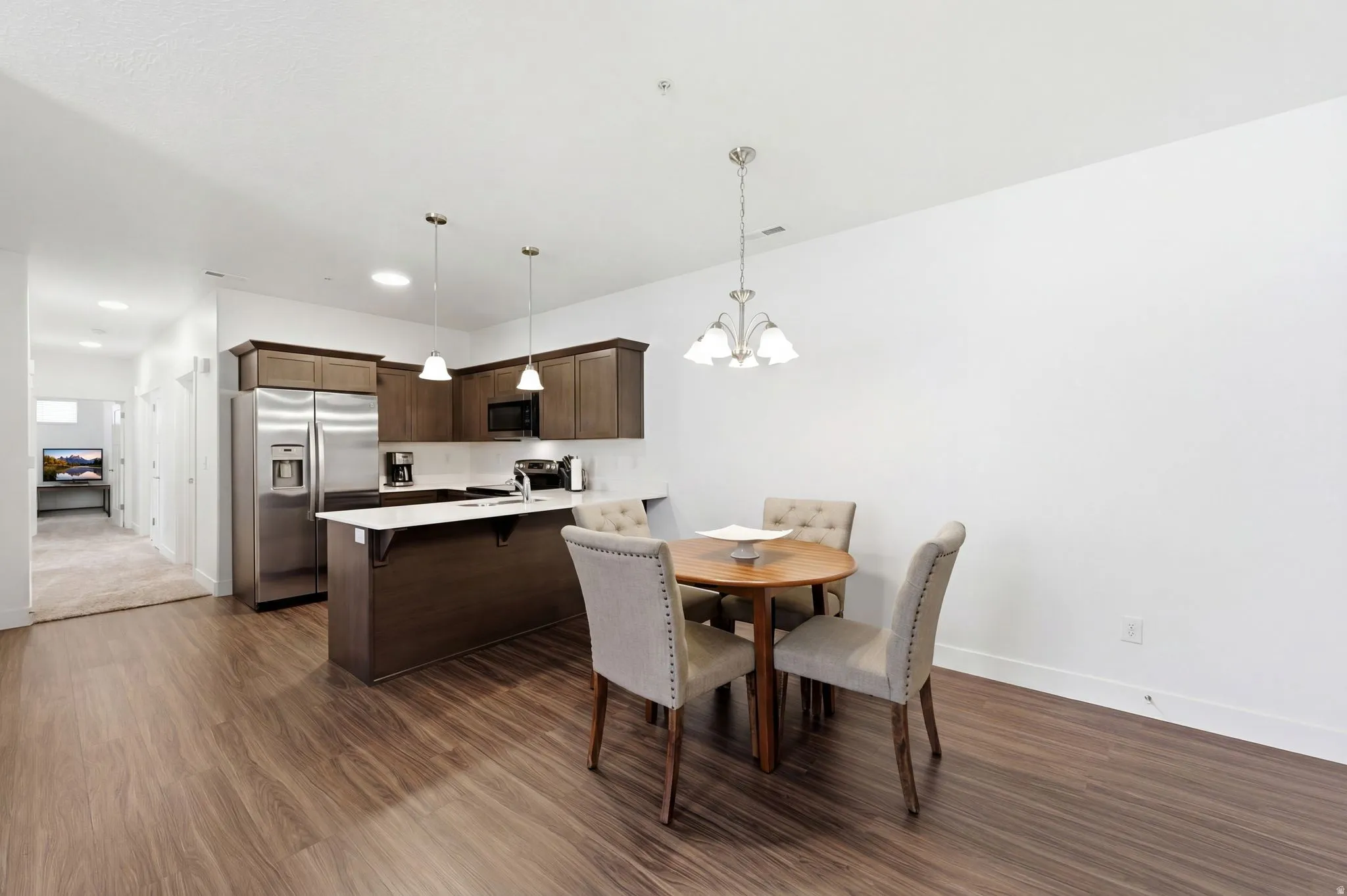 Dining area with dark wood-type flooring and a chandelier