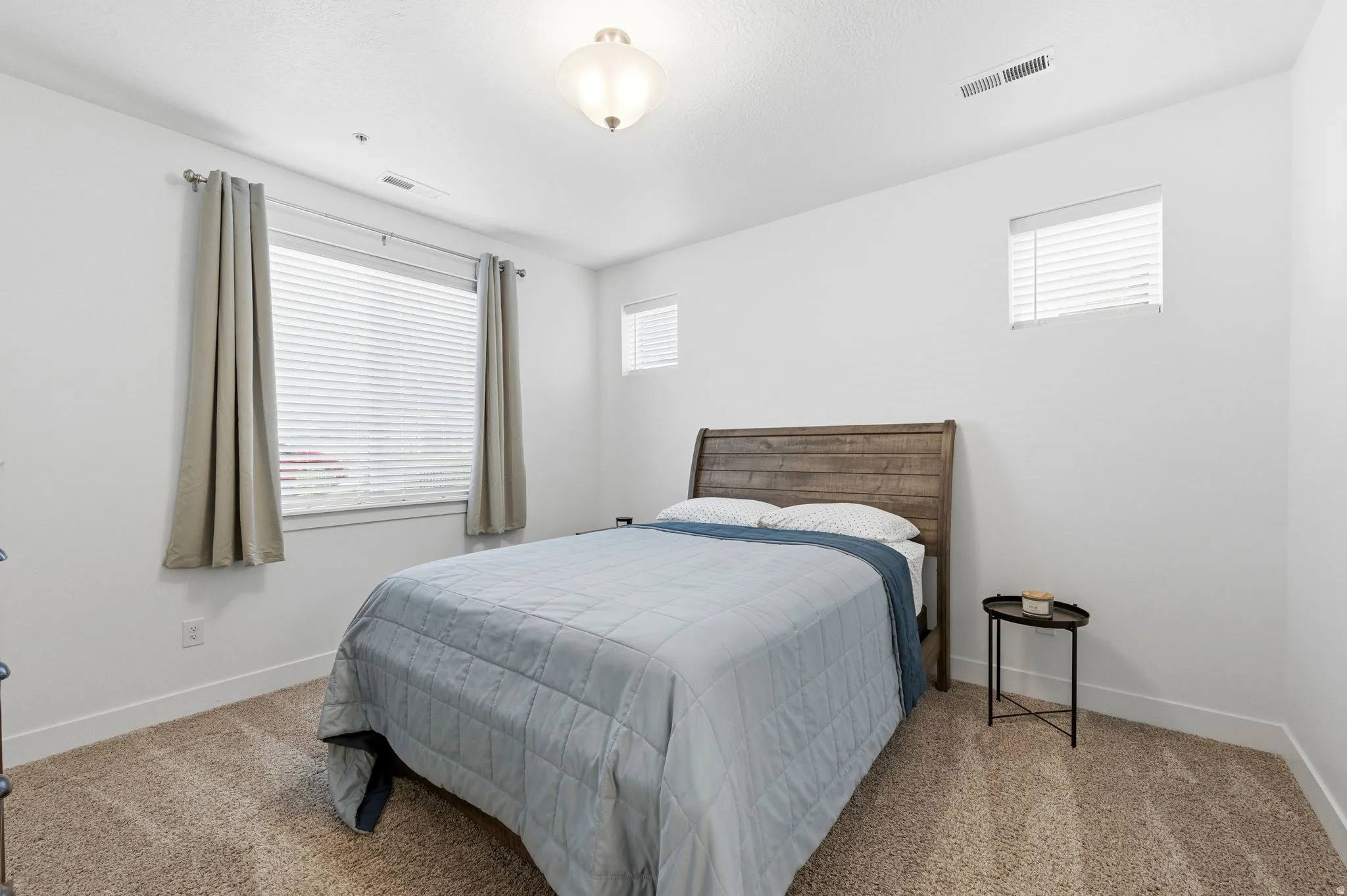 Carpeted bedroom featuring multiple windows