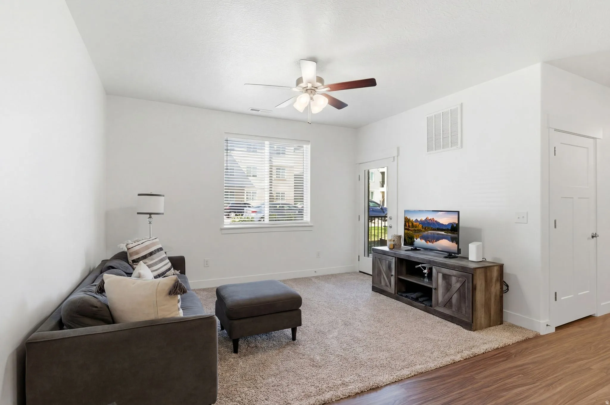 Living area with a ceiling fan and wood finished floors