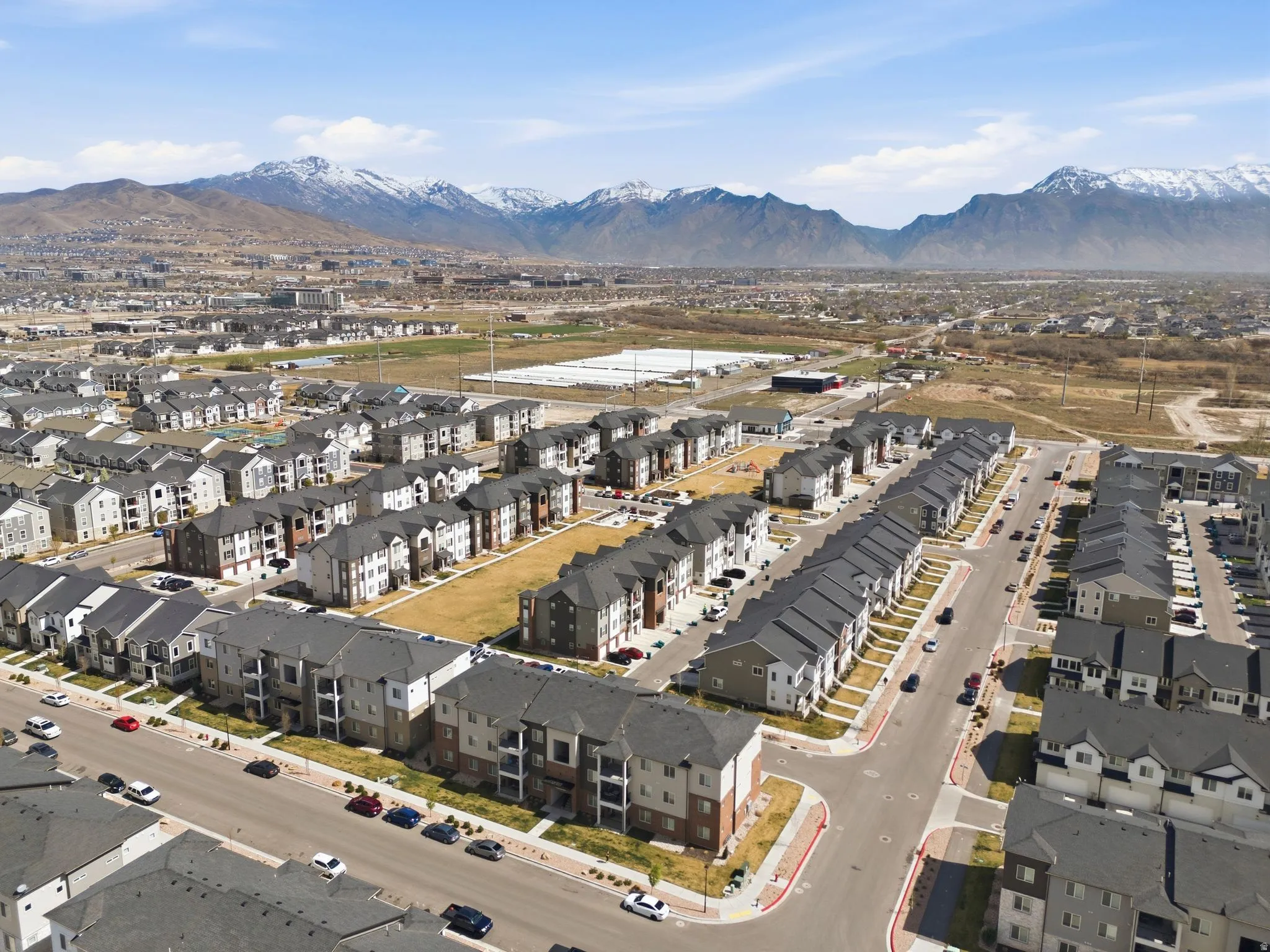 Aerial view of property and surrounding area with mountains and nearby suburban area