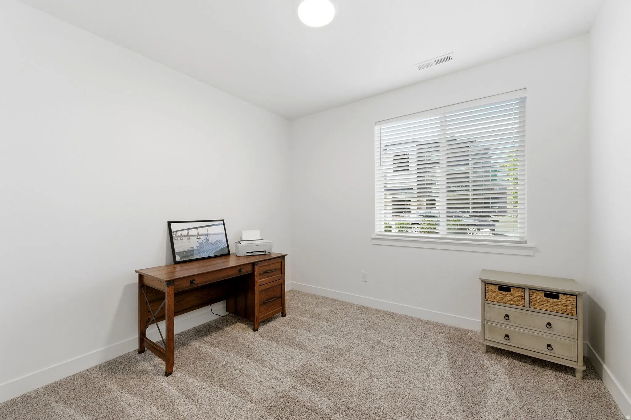 Office space with light carpet and baseboards