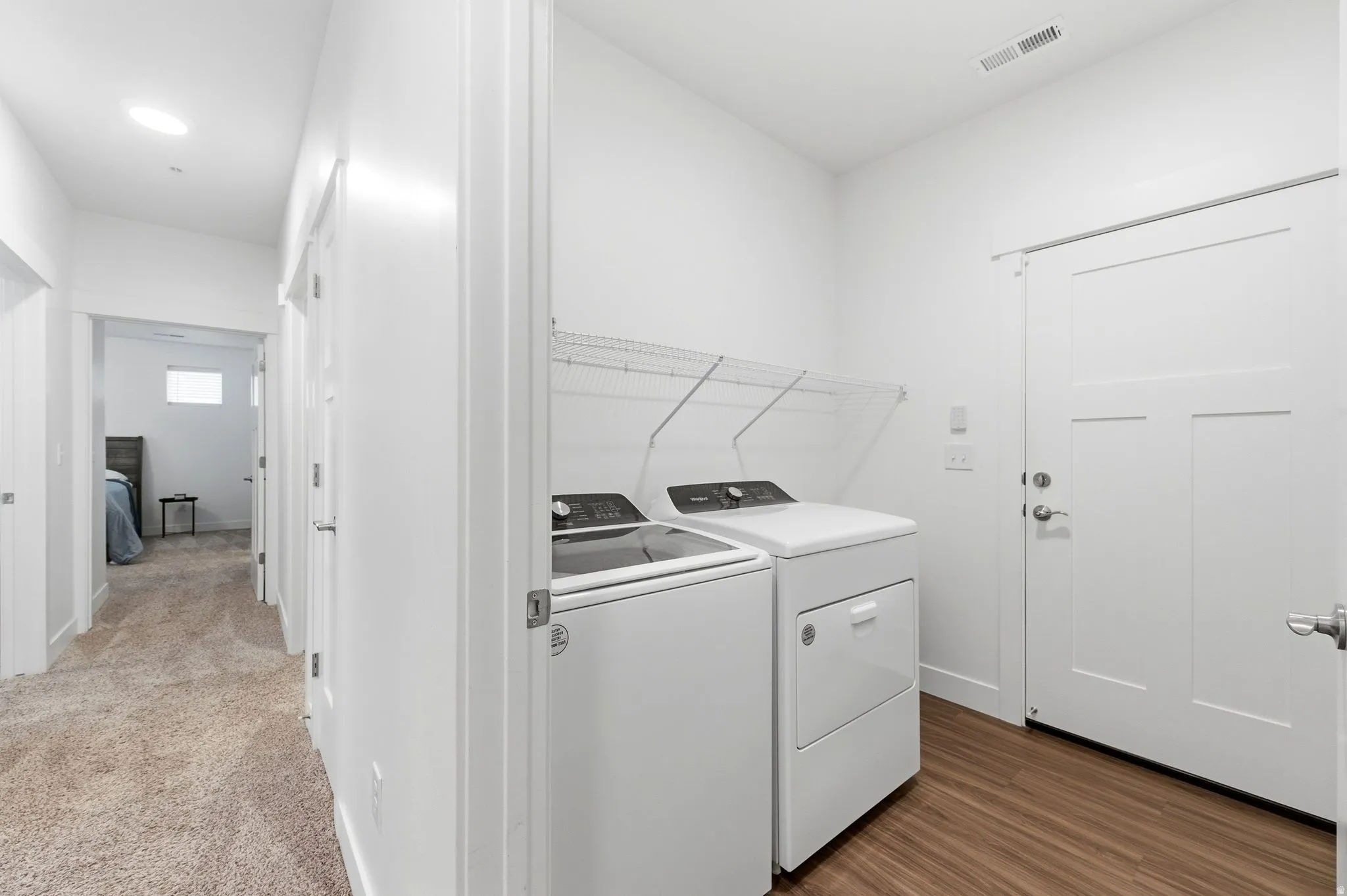 Laundry area featuring separate washer and dryer and dark wood-style flooring
