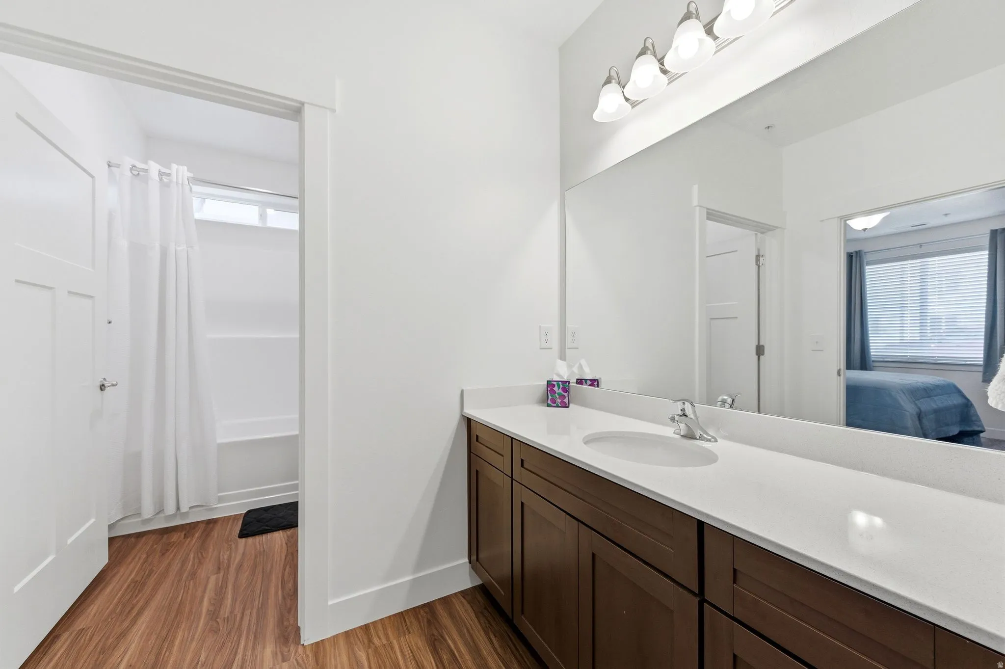 Ensuite bathroom with vanity, dark wood finished floors, and shower / bath combination with curtain