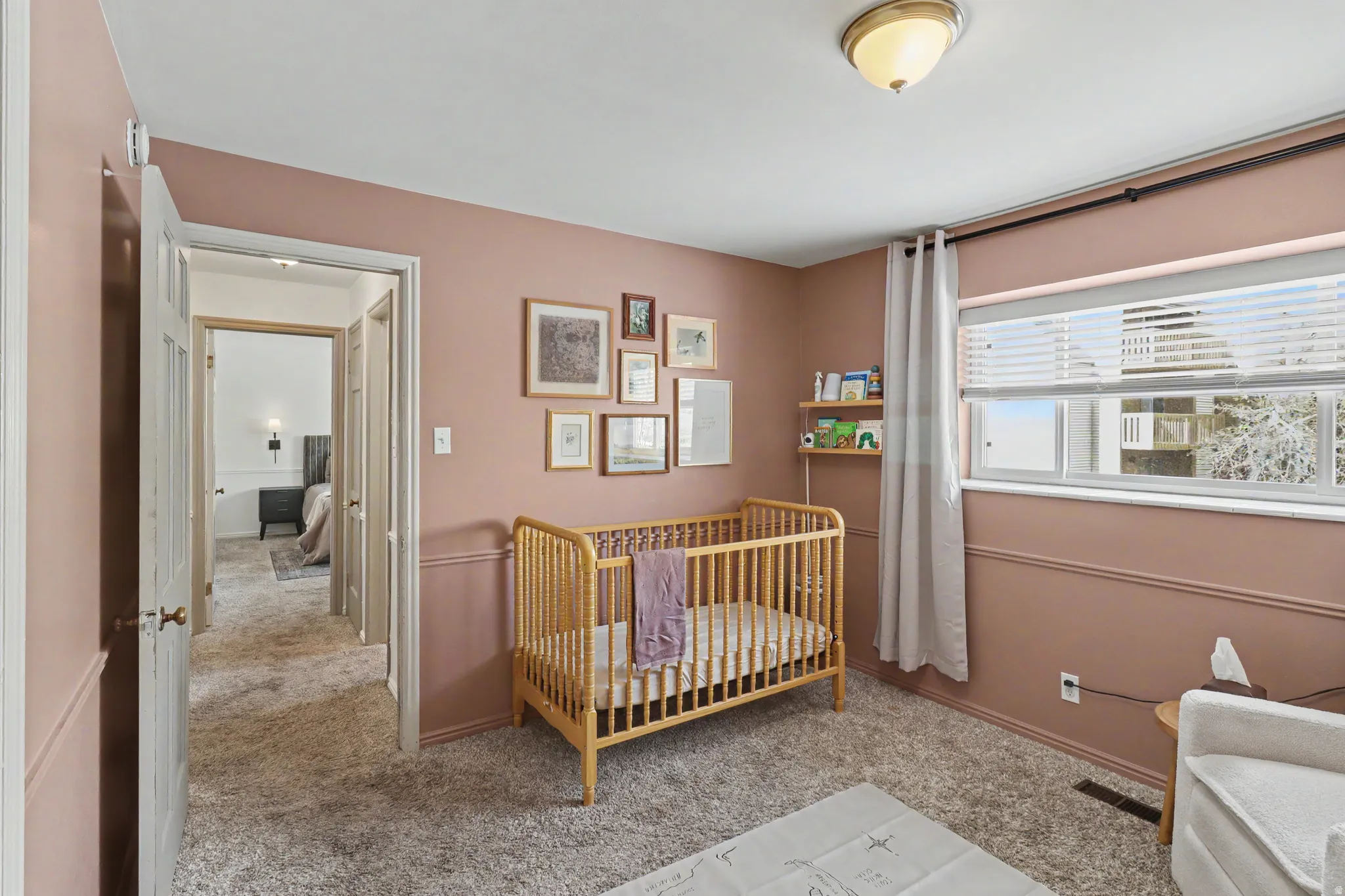 Bedroom with light carpet and a crib