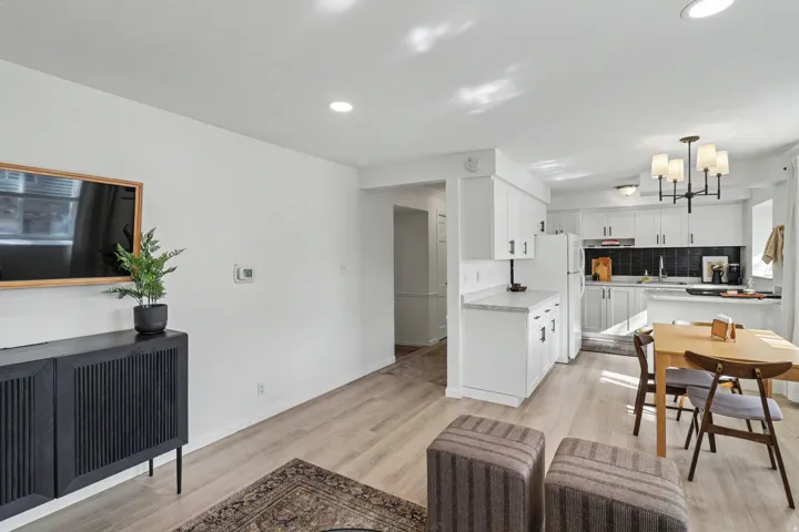 Living area with hanging lights and light wood-style flooring