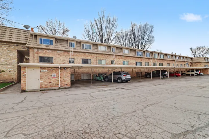 View of apartment building / complex with covered parking