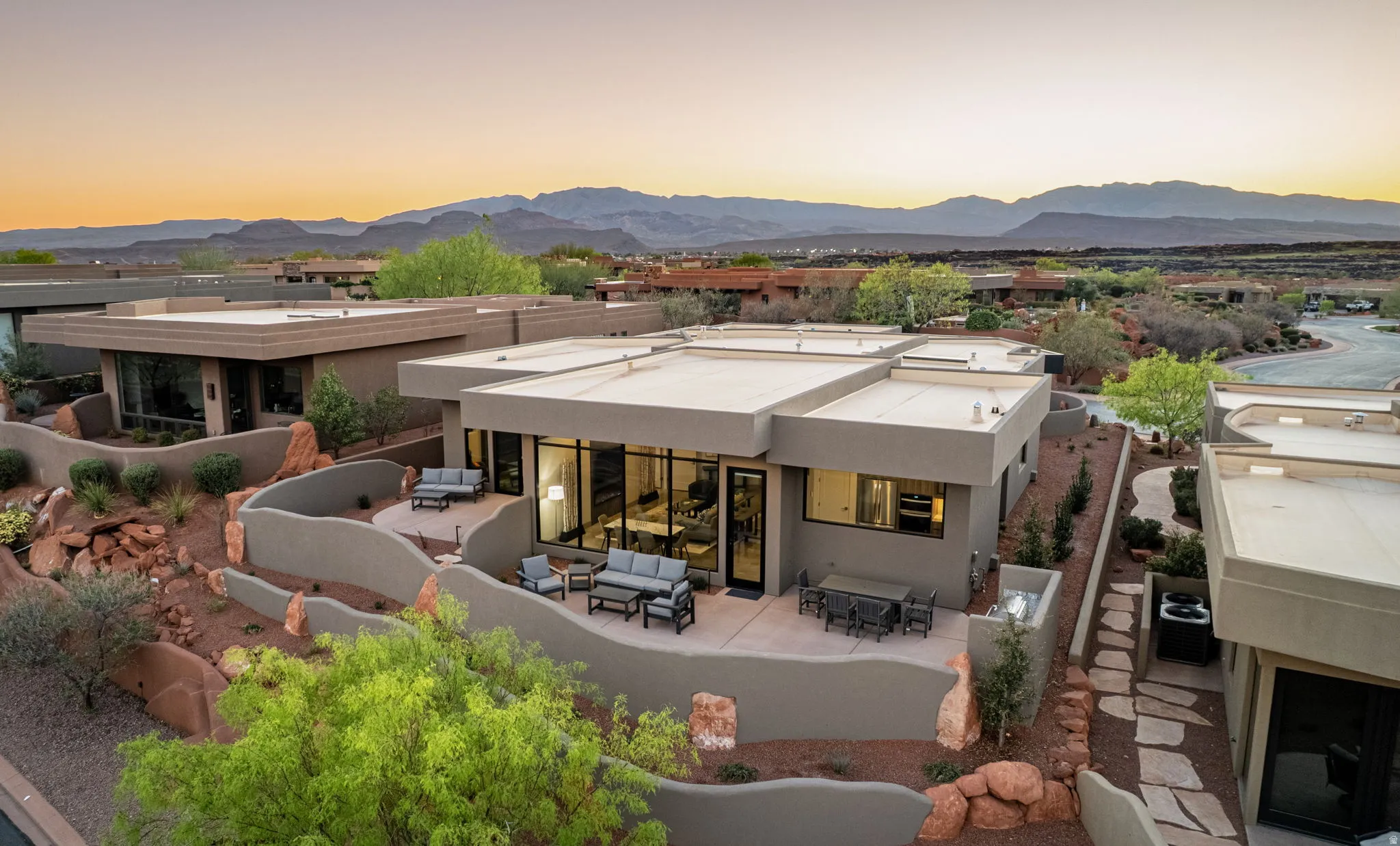 Rear view of property with stucco siding, a fireplace, a mountain view, a patio, and outdoor lounge area