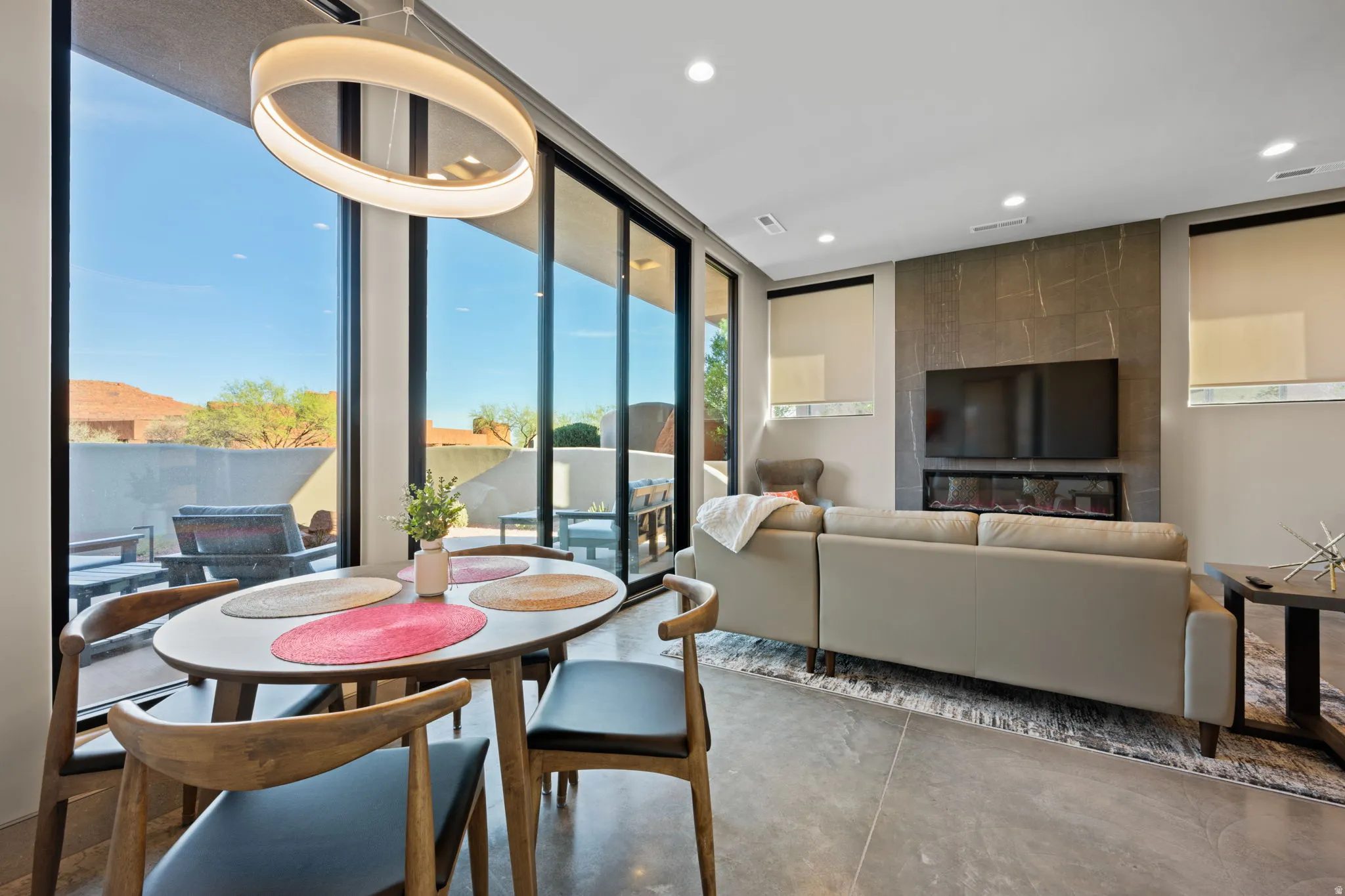 Dining room featuring concrete flooring, floor to ceiling windows, and recessed lighting