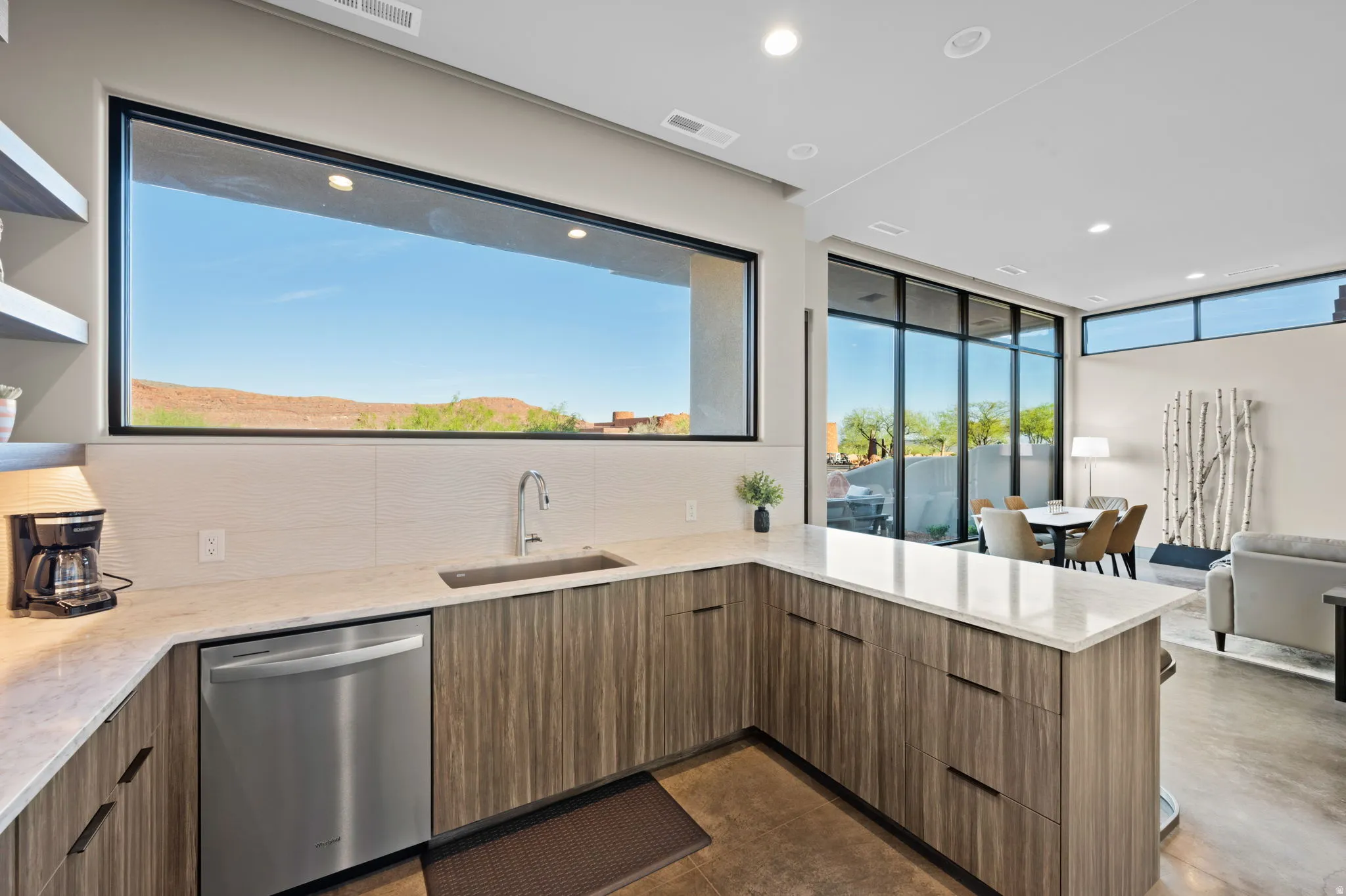 Kitchen with open floor plan, light stone countertops, stainless steel dishwasher, modern cabinets, and a peninsula