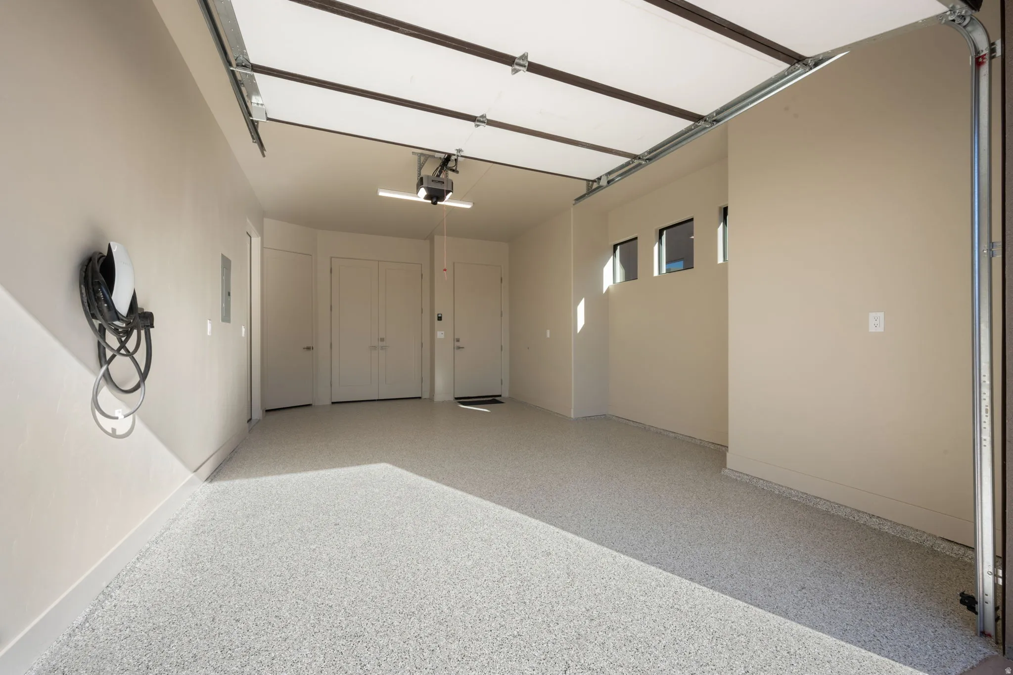 Garage featuring baseboards and electric vehicle charger