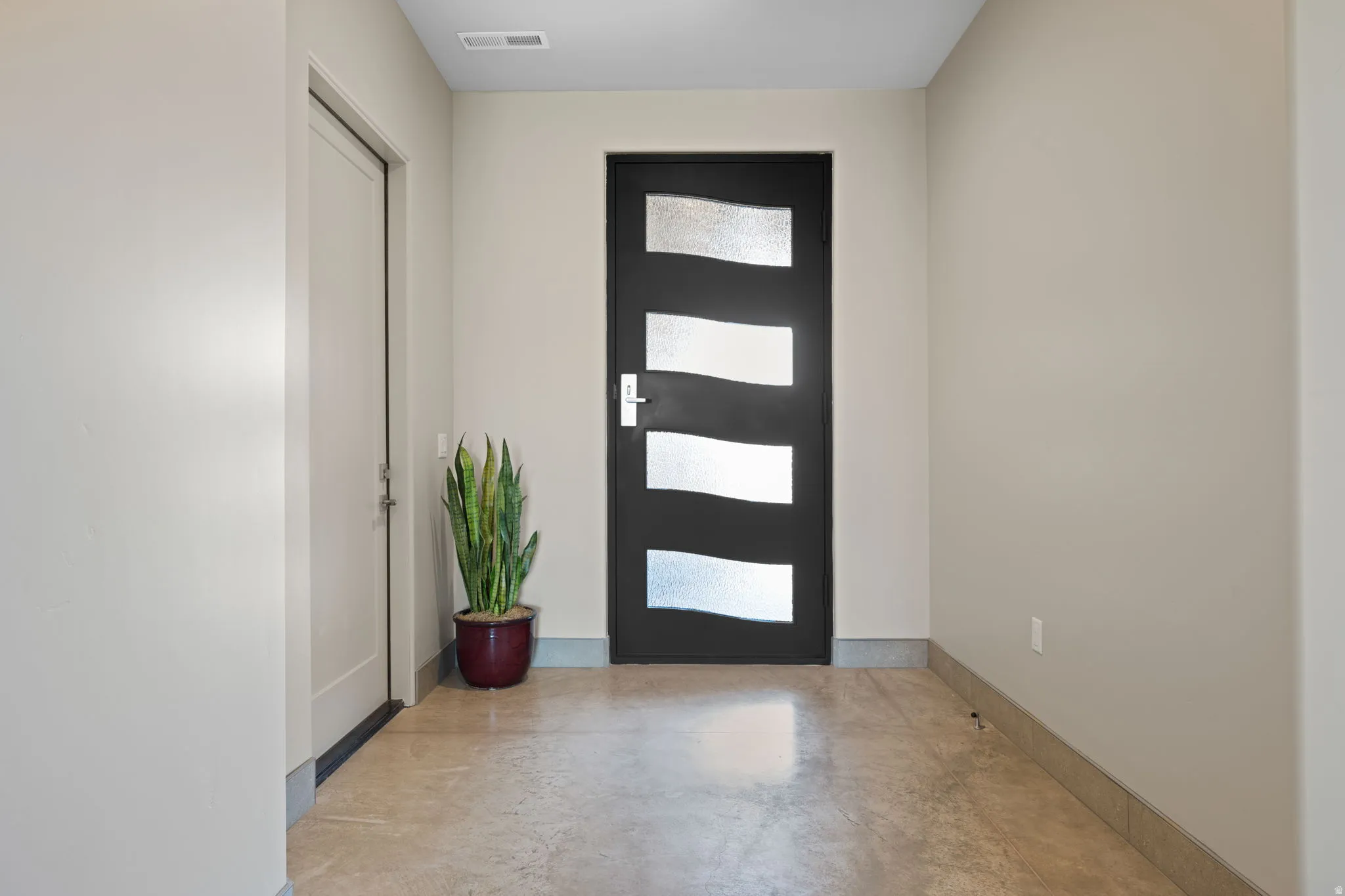 Entryway featuring finished concrete floors and baseboards