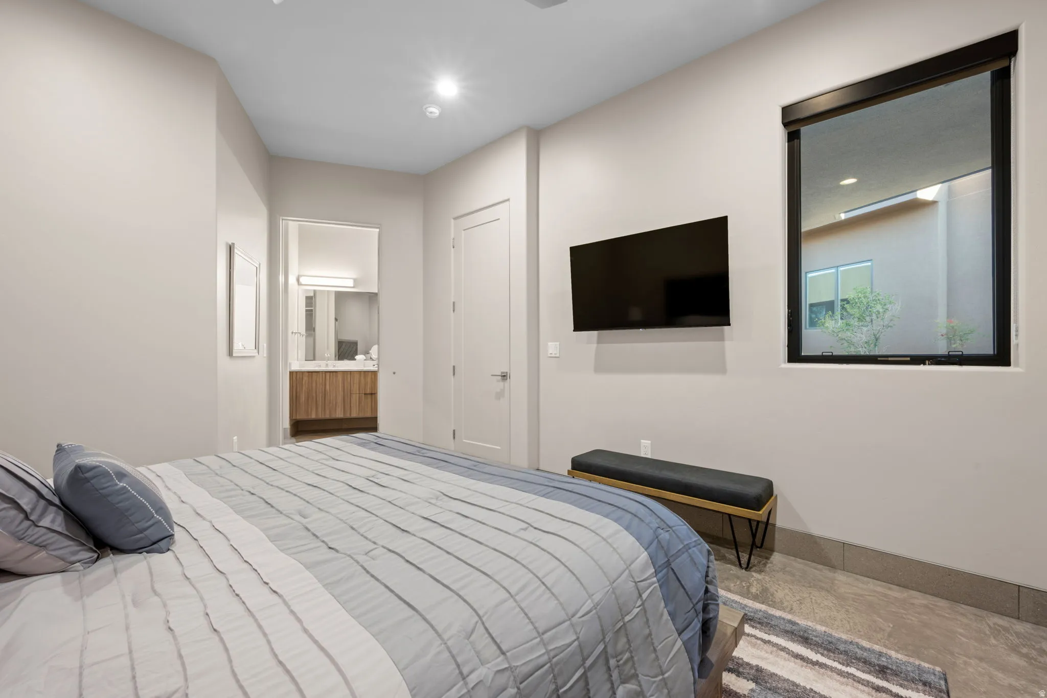 Bedroom with ensuite bath and recessed lighting