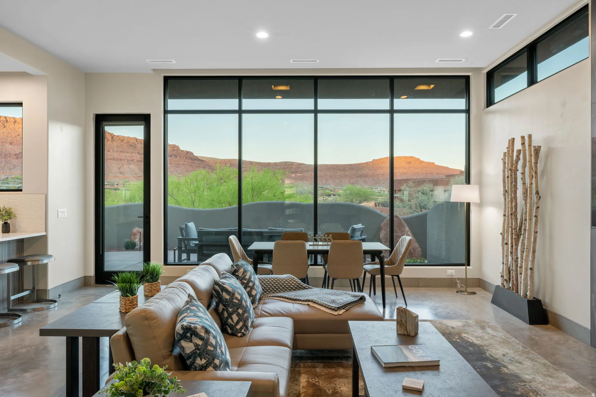 Living room featuring finished concrete floors, a mountain view, floor to ceiling windows, and recessed lighting