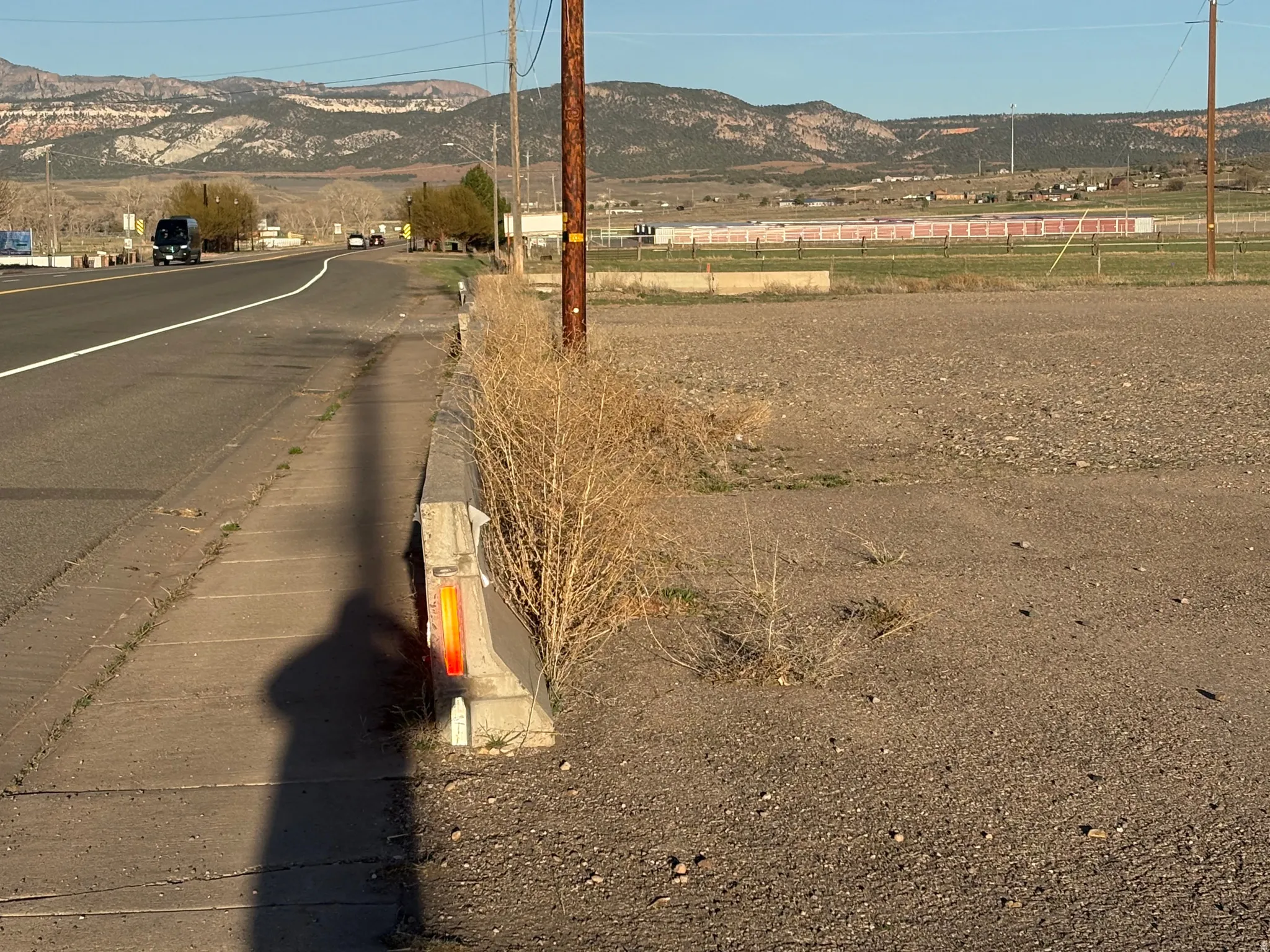 View of asphalt street featuring a mountain view, curbs, and a rural view