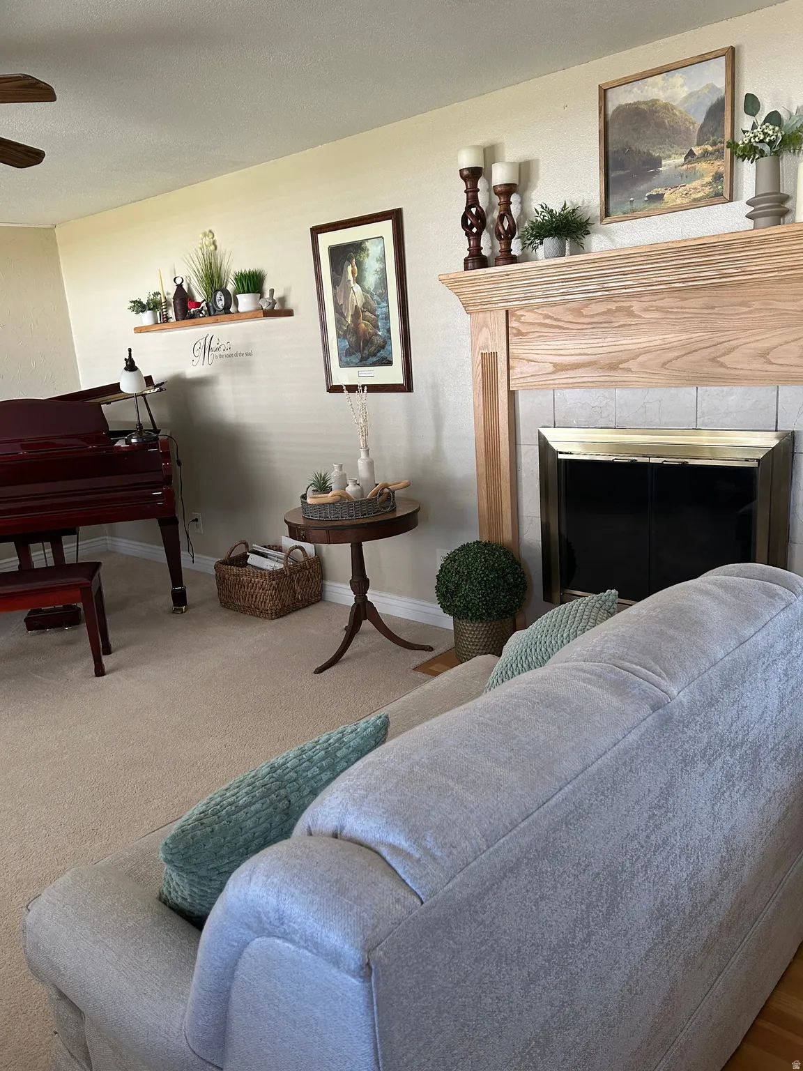Sitting room with a tiled fireplace, a ceiling fan, and carpet