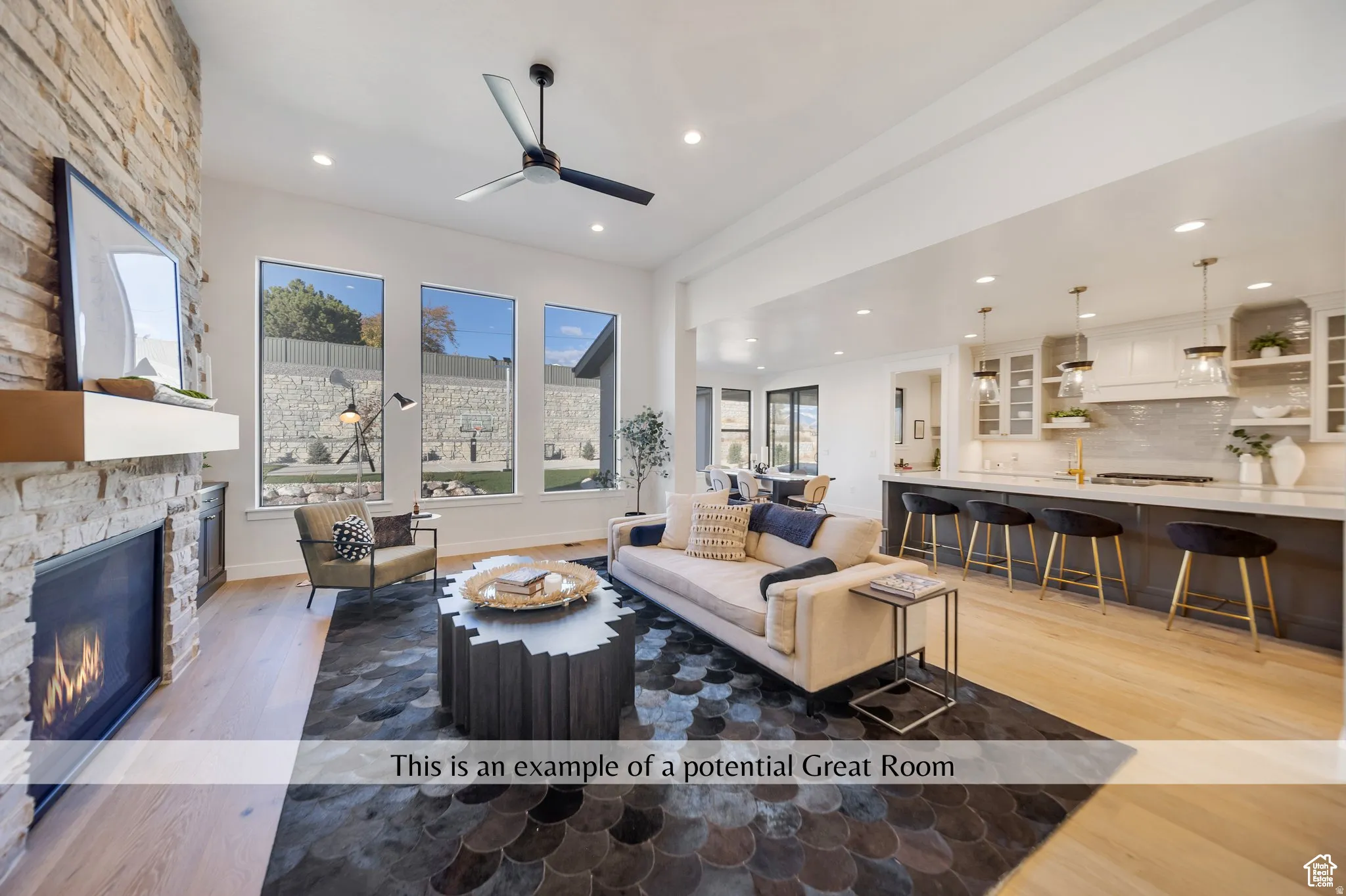 Living room with a stone fireplace, recessed lighting, light wood-style floors, and a ceiling fan