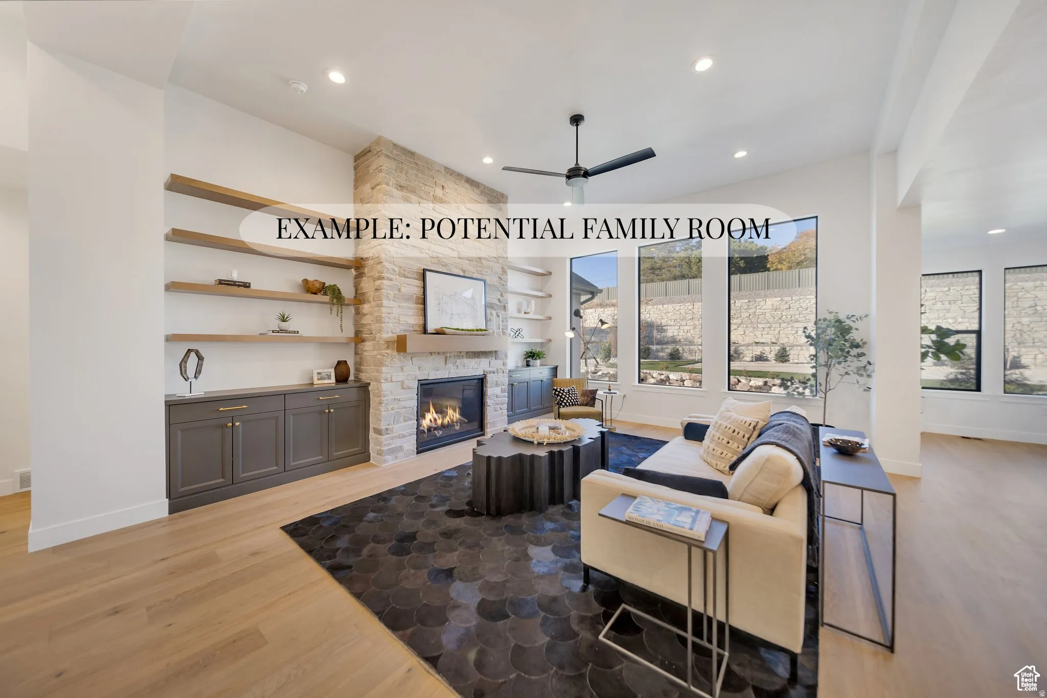 Living room with light wood finished floors, a ceiling fan, a fireplace, and recessed lighting