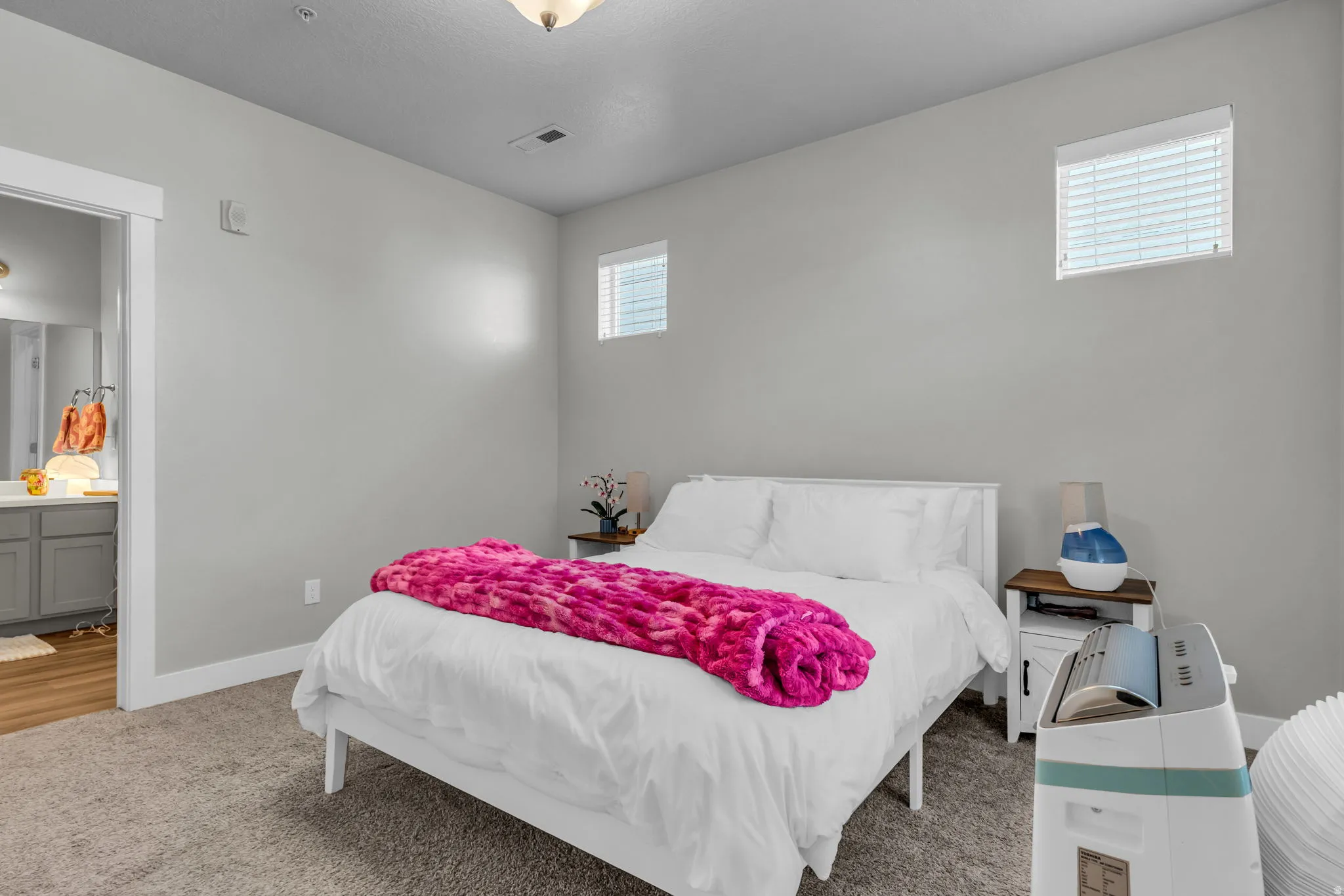 Carpeted bedroom with baseboards and connected bathroom