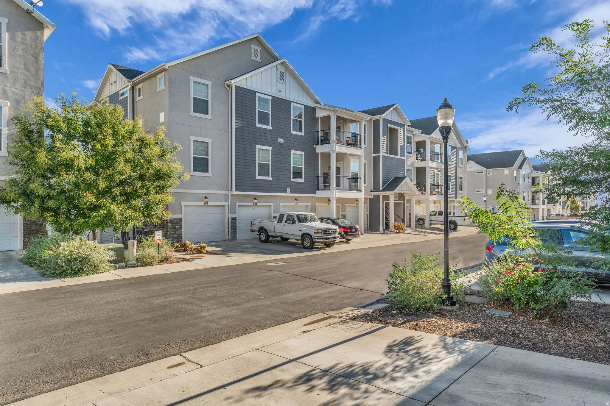 View of concrete road with street lights, a residential view, and sidewalks