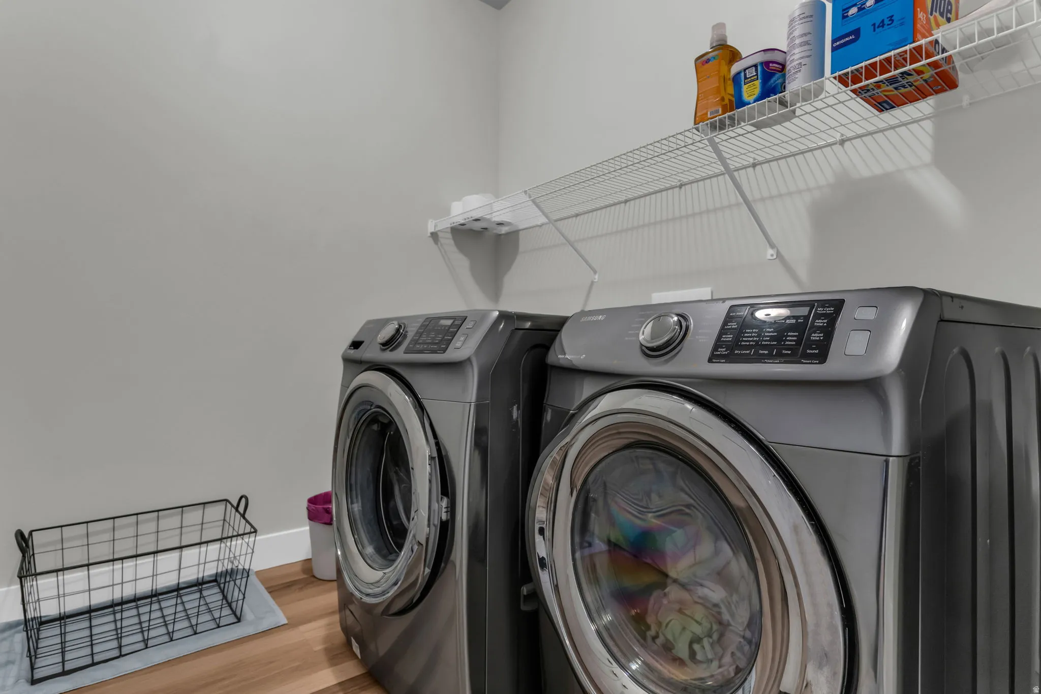 Laundry area featuring light wood-style flooring and washing machine and clothes dryer