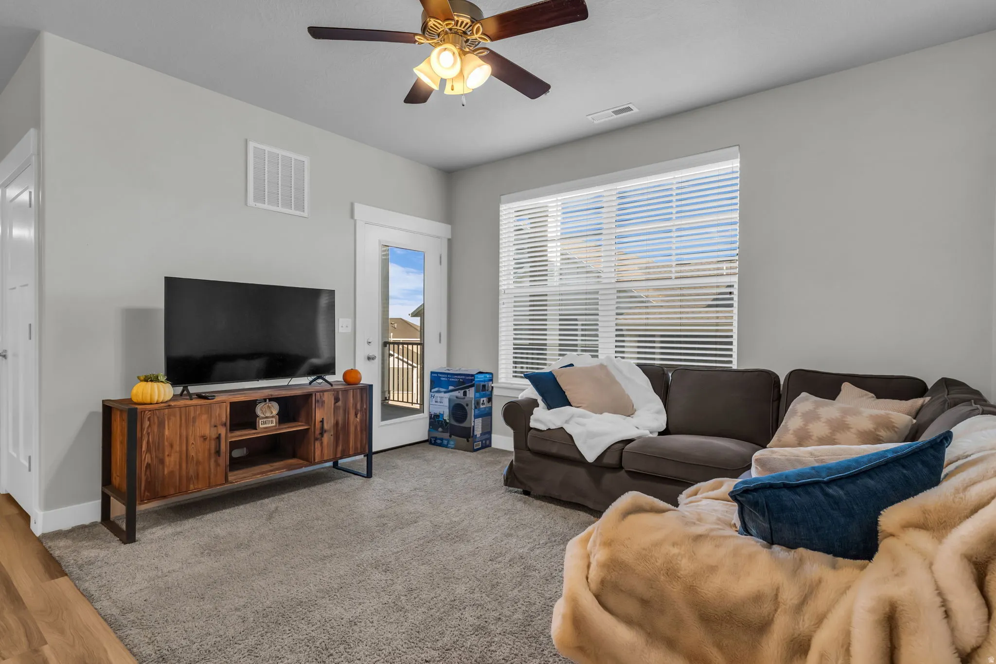 Living area with ceiling fan and wood finished floors