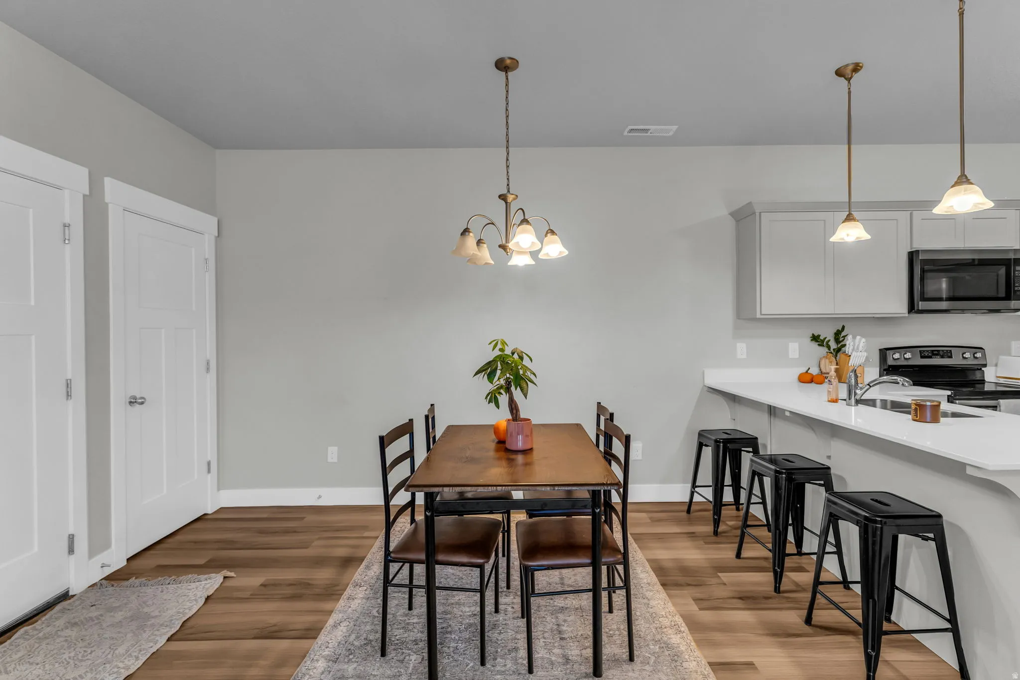 Dining area with hanging lights and light wood-type flooring