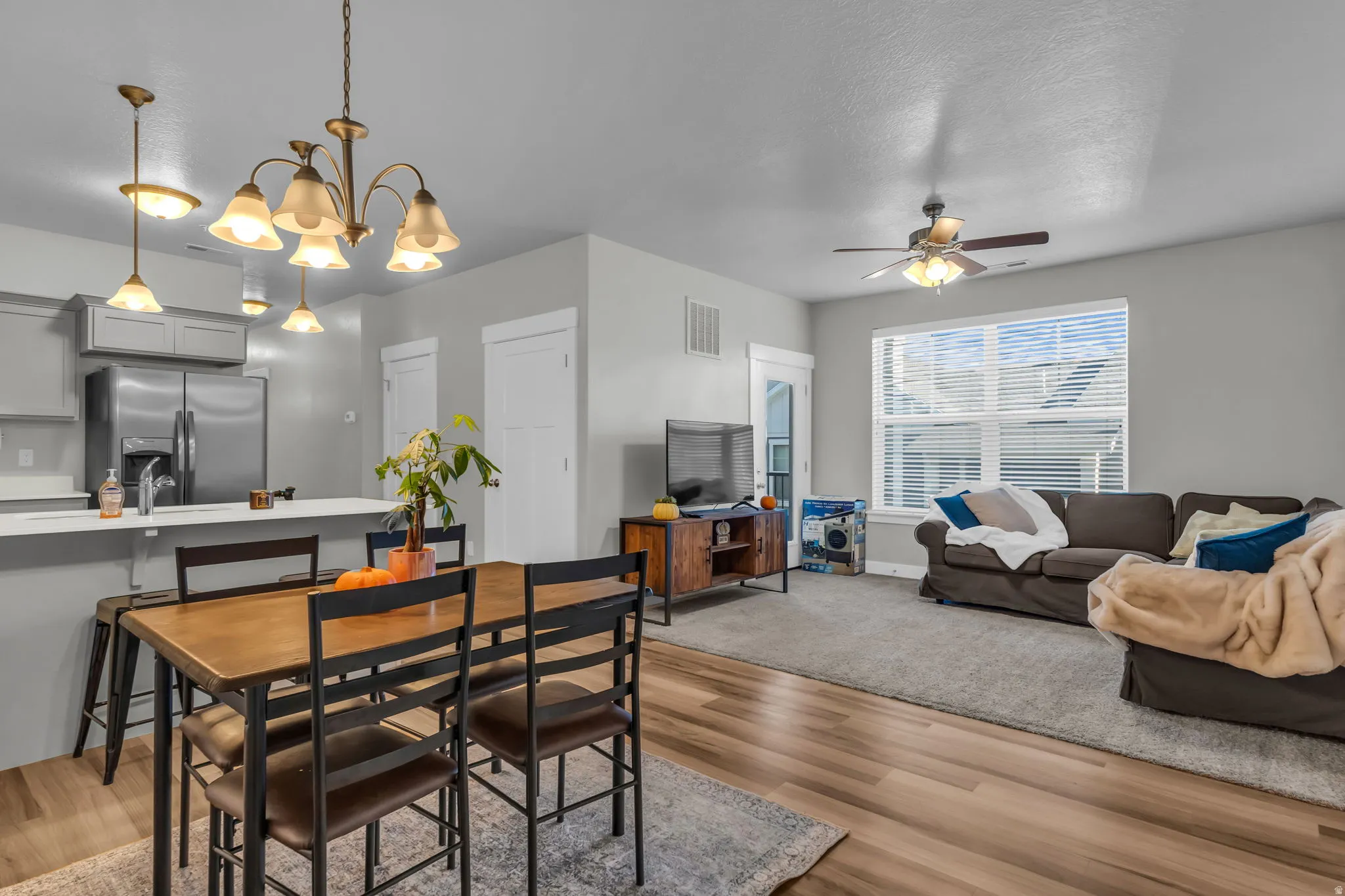 Dining area featuring light wood-style flooring, a chandelier, and a ceiling fan