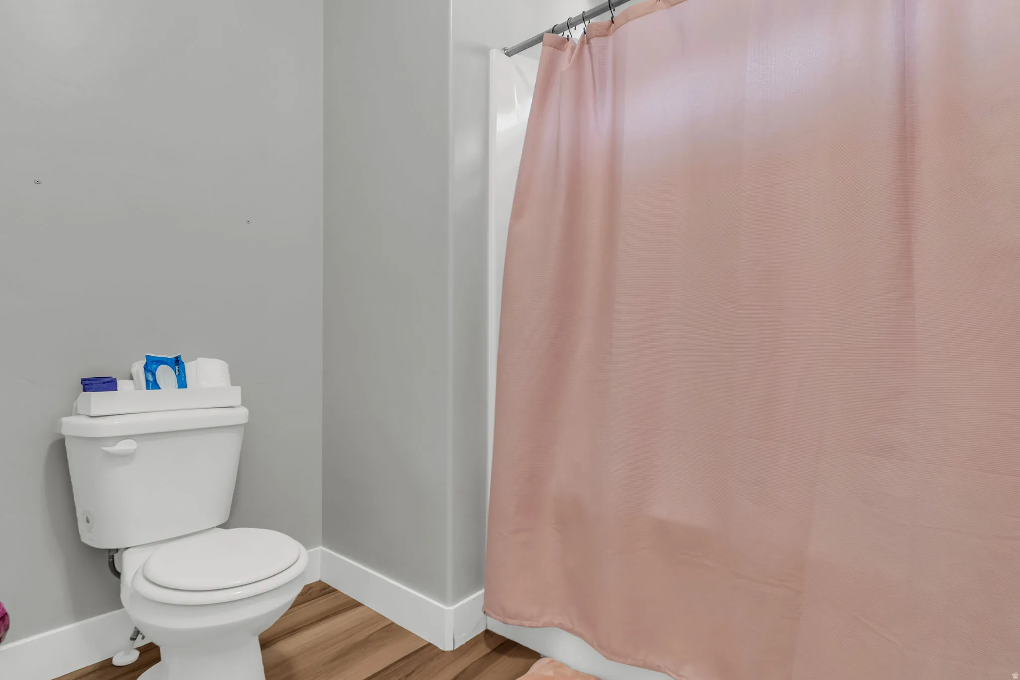 Bathroom featuring light wood-style flooring and shower / tub combo